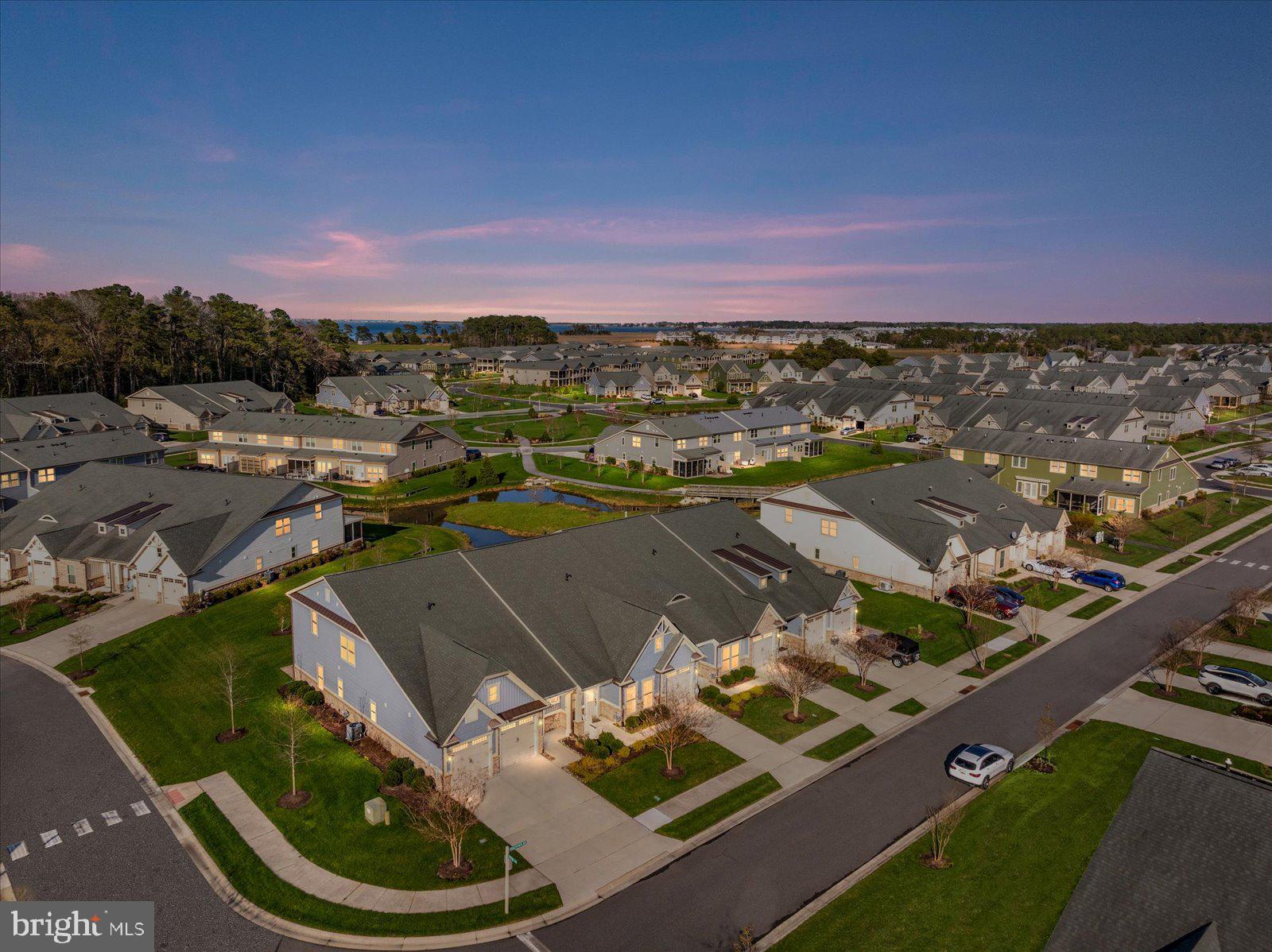 First time on the market, just minutes from beautiful Bethany Beach, nestled within the highly sought-after community of Bay Forest, awaits an exceptional opportunity at 26409 Kingfisher Rd. This stunning, two story Monocacy model by NV Homes offers the ease of first-floor living paired with the spaciousness and elegance of a luxury villa design. This was a third home and never a rental. Boasting over 3000 square feet, this beautifully appointed townhouse features 4 bedrooms, 4.5 bathrooms, plus an office that can become a fifth bedroom and a separate laundry room with a washer and dryer and an impressive list of upgrades and premium features that truly set it apart. The home’s curb appeal makes a lasting impression with manicured landscaping, a one-car garage, private driveway, and charming front porch welcoming you inside. Step through the elegant foyer with its striking tray ceiling and immediately experience the bright, open-concept design that defines this remarkable home. Rich hardwood flooring flows seamlessly throughout the living spaces, creating warmth, sophistication, and effortless flow for both everyday living and entertaining. The expansive living room is both inviting and impressive, featuring soaring ceilings, abundant natural light, and a dramatic floor-to-ceiling stone fireplace with mantel that serves as a stunning focal point. Large windows frame peaceful pond views, creating a serene backdrop that can be enjoyed from nearly every angle of the main living area & primary suite. At the heart of the home is the gourmet kitchen - a dream for anyone who loves to cook or entertain. Gorgeous cabinetry, granite countertops, tile backsplash, oversized island with breakfast bar seating, stainless steel appliances including a gas cooktop, and a spacious pantry combine beauty with functionality. In addition, the home offers an enormous walk-in storage area that is truly a rare & valuable feature. These thoughtfully designed spaces help to keep the home organized without sacrificing living areas or closet space. One of the home’s most desirable features is the presence of two ensuite bedrooms on the main level. The luxurious primary suite offers a spacious sitting area, a wall of windows overlooking tranquil pond views, and a spa-inspired bath complete with dual vanities, a large walk-in closet, and an oversized walk-in shower with bench seating. The second ensuite bedroom is conveniently located near the foyer, plus a powder room & coat closet provide added convenience for guests. Upstairs, you’ll discover an expansive family room along with a private office featuring French doors. Two additional bedrooms with 2 full bathrooms add even more comfort and flexibility for family and guests. The outdoor living spaces are every bit as impressive as the interior. Just off the living room, the screened porch creates the perfect extension of the home — an ideal spot for morning coffee, evening cocktails, outdoor dining, or simply relaxing while enjoying the peaceful pond views and sounds of nature. Beyond the porch, the spacious patio offers additional room for entertaining, grilling, lounging, or gathering around a fire table under the stars. The half wall surrounding the patio adds architectural charm while also providing the perfect place for potted flowers, herbs, or seasonal greenery. Together, the screened porch, patio, and open water views create a private outdoor retreat that captures the very best of coastal living. 26409 Kingfisher Rd. is truly a standout property, offering the perfect blend of luxury, comfort, storage, and thoughtful design in one of the area’s most amenity-rich communities. Residents of Bay Forest enjoy access to two resort-style pools, tennis and pickleball courts, a recreation center, game room, playground, and even a convenient beach shuttle. This exceptional property is being offered unfurnished. Schedule your private showing today and discover why life truly is better at Bay Forest.