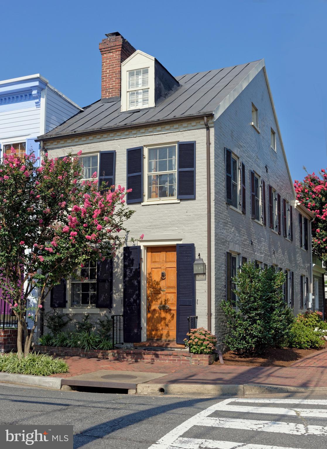 You must see this fabulous historic house, circa 1799, in the Southeast quadrant of Old Town!  Located on South Lee Street caddy corner from Windmill Park and with a view of the Potomac River, history speaks to the interior original floors and moldings and modern architecture speaks with the recent kitchen-breakfast room addition, designed by Patrick Camus.  Semi-detached with windows on 3 sides, natural light flows into this house from the many windows on the Gibbon Street side.  The original fireplace mantel creates a great atmosphere with the additional bookshelves in the living room.  A spacious dining room is currently being used as a music room for the owner's daughters.   You'll be thrilled with the stunning kitchen addition with custom cabinets, tiled floor, quartzite counter tops.  A chef's dream of a Bertazzoni range and hood are right here for wonderful meals along with the long useful island.  Pella triple paned windows in the breakfast room allow for more natural light, and the  banquettes lift for storage.  French doors open to a deep patio with a pergola and fan, the ideal place for a glass of wine or alfresco dinner.  2 spacious bedrooms plus a library are on the second floor with a beautifully  renovated bath.  Looking through the primary bedroom windows you can see the river!  Architectural tiles are found in the primary renovated bath.   The irresistible part of this second floor is the enormous outdoor deck overlooking the patio and the mature crape myrtle tree.  The 3rd bedroom and renovated bath are on the top floor with another view of the river.  Don't miss the lower level, with tall exposed brick wall, all renovated space with wood floors, a standing working desk, another laundry, and MANY closets to hold everything from tubs of holiday decorations to fishing poles.  This is a one-of-a-kind house that has been lovingly cared for and renovated.  History of ownership includes a major ship builder, 2 Alexandria mayors and a well known sports figure.