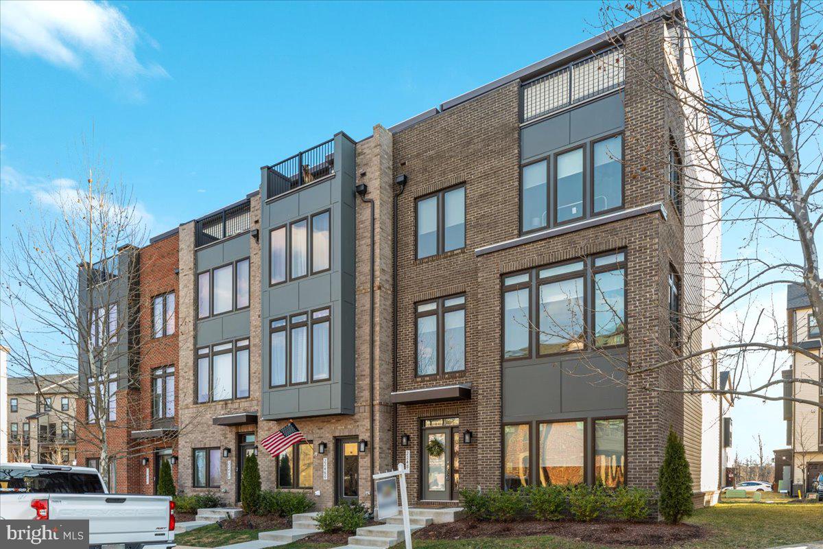 Welcome to this exquisite, sun-filled townhome, located in the highly sought-after Metro Walk community. This beautifully designed, brand-new 2022 build offers over 3,400 square feet of luxurious living space across four levels, featuring 4 bedrooms, 3 full bathrooms, and 2 half baths.

This home is perfect for both entertaining and comfortable family living. The main living level boasts a gourmet kitchen with designer upgrades, including a large center island, granite countertops, a sleek vent hood, gas cooking, wall oven, built-in microwave, and a French-door refrigerator. The kitchen flows seamlessly into the dining room and sitting room, where expansive windows invite abundant natural light, creating a bright and airy atmosphere.

The entry level includes a versatile bedroom and a full bath, ideal for guests or a private home office. Upstairs, you’ll find two generously-sized guest bedrooms, a full bathroom, and a convenient laundry room with a full-size washer and dryer.

The top level is perfect for relaxation or play, offering a spacious recreational area with a half bath and access to a private rooftop terrace. Unwind with stunning panoramic views – the perfect spot for outdoor entertaining or simply enjoying the beauty of the surrounding landscape.

With ample space, high-end finishes, and multiple outdoor areas including a two-car garage and driveway, this townhome truly checks all the boxes. A short walk to the Ashburn Metro station, community amenities, and plenty of overflow parking make this location as convenient as it is beautiful.