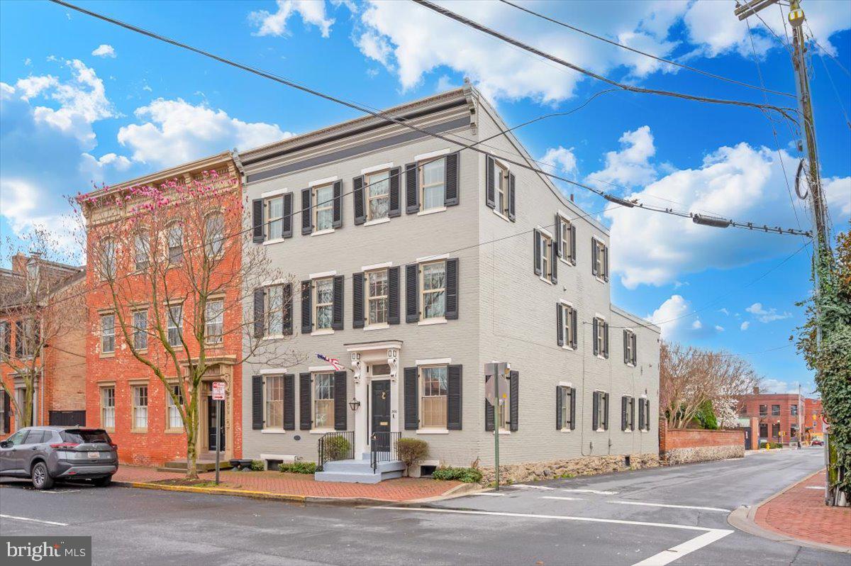 **1 year garage parking and 1 year street permit parking included!!** Circa 1880, this downtown Frederick home carries the kind of character you simply can’t recreate. Set right on Church Street—one of the most recognizable and loved streets in the city—this six-bedroom property blends historic detail with the right modern updates in a way that actually feels natural, not forced. Inside, the home immediately shows off what makes these properties so special. Original solid hardwood floors run throughout, paired with exposed brick and timber that have been preserved rather than covered up. There’s a sense of depth and texture here that newer homes just don’t have. Every room feels intentional, with just the right balance of old and new. The kitchen has been completely redone with a clean, high-end finish, designed for someone who enjoys cooking and entertaining. It opens comfortably into the main living areas, making the flow of the home feel easy and connected without losing the defined spaces that give older homes their charm. With six true bedrooms, there’s a lot of flexibility here—whether you need space for guests, offices, or just room to spread out. Each level has its own full bathroom, which makes day-to-day living simple and practical, especially for a home of this size. Out back, the courtyard feels like a true extension of the home. Surrounded by exposed brick walls, the space is both private and full of character, with thoughtful landscaping that brings it to life throughout the year. In the spring and summer, it naturally fills in with color and greenery, creating a setting that feels tucked away and quiet despite being right in the middle of downtown. Whether you’re hosting friends or just stepping outside for a few minutes, it’s a space that is timeless in its beauty. One of the standout features is the outdoor space above ground level. The primary bedroom includes its own private balcony, while the third-floor balcony offers a view that’s hard to come by—looking out over the steeples of downtown Frederick. It’s a subtle reminder of exactly where you are, and why people love being here. All of this sits just steps from everything downtown Frederick has to offer—restaurants, shops, coffee, and the overall energy that makes this area so desirable. Homes like this don’t come around often, especially ones that have been updated in a way that still respects what they are. This is one you feel the moment you walk in. OPEN SATURDAY APRIL 18TH 11 - 1 P.M. - STOP BY AND TOUR THIS AMAZING HOME!