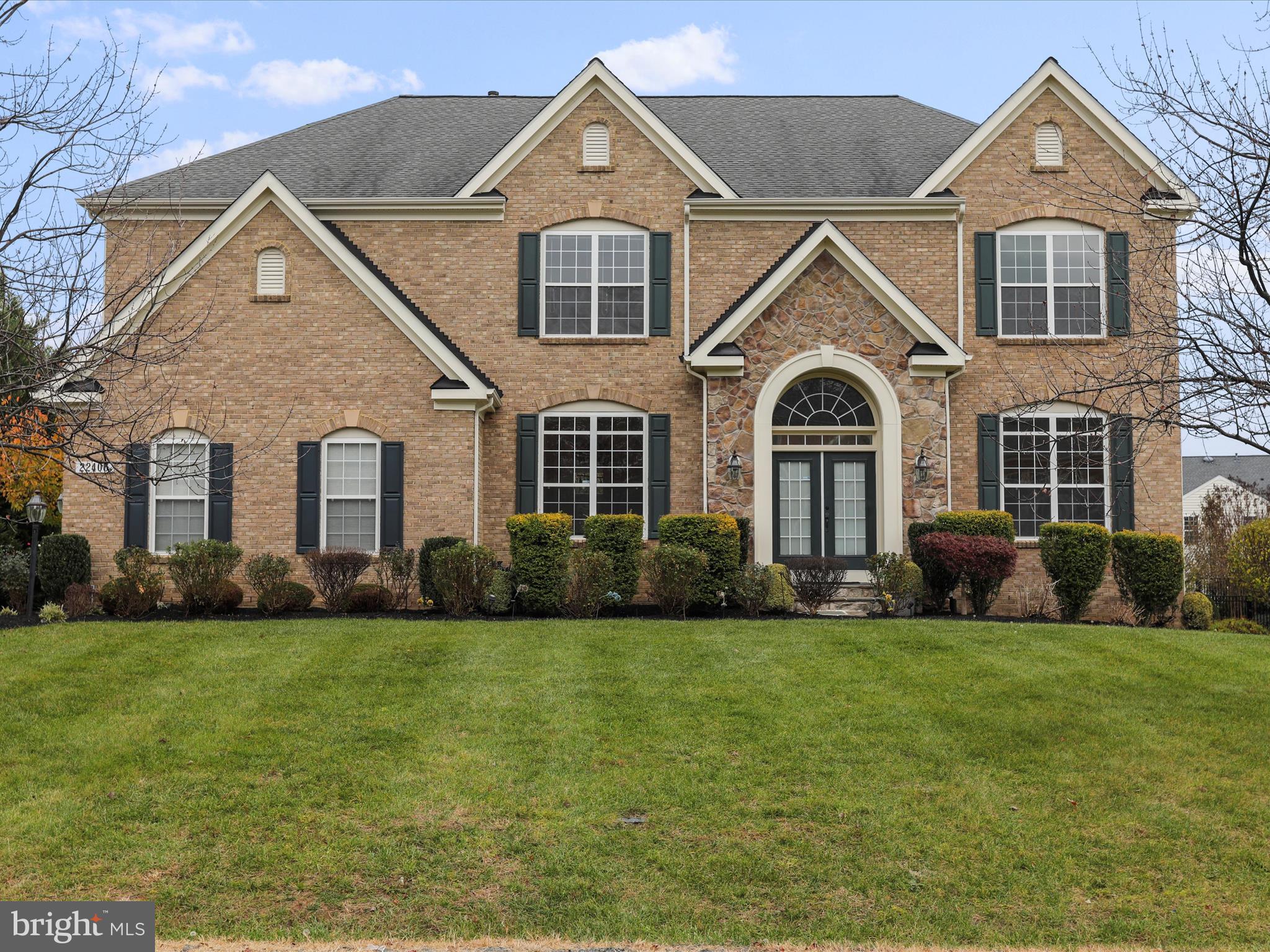 Step into timeless sophistication at this stunning brick-front colonial located in the highly sought-after Park at Belle Terra community. With over 6,000 square feet of beautifully finished living space, this 5-bedroom, 5.5-bathroom home combines classic design with modern comforts. The main level boasts a two-story grand entry foyer with a striking curved staircase, a gourmet kitchen featuring upgraded countertops, a spacious island, and a walk-in pantry, and a family room warmed by a gas fireplace. Entertain in style in the formal dining room adorned with elegant wainscoting, or retreat to the private office complete with a walk-in closet. Gleaming hardwood floors run throughout the level, adding to its charm and elegance.

The upper level is a sanctuary of comfort with a luxurious primary suite featuring a tray ceiling, a sitting area, and dual walk-in closets. The primary bath includes a double vanity, a jetted soaking tub, and a separate shower. Four additional bedrooms—two with private en-suite baths and two sharing a Jack-and-Jill bathroom—provide plenty of space for family and guests. The convenience of an upper-level laundry room further enhances the home’s appeal.

The partially finished basement is ideal for recreation and extended living, featuring a kitchenette, a spacious recreational area, an additional room with a walk-in closet, and a full bathroom. A walk-out staircase leads to the large, tree-lined backyard, offering a peaceful retreat complete with a rear deck and a level lawn, perfect for outdoor gatherings. The side-entry garage adds both style and practicality to this impressive home.

Located in the heart of Ashburn, the Park at Belle Terra offers a serene yet connected lifestyle, with nearby shopping, dining, schools, and easy access to commuter routes. Discover unparalleled elegance and comfort at 22406 Dolomite Hills Drive—your dream home awaits!