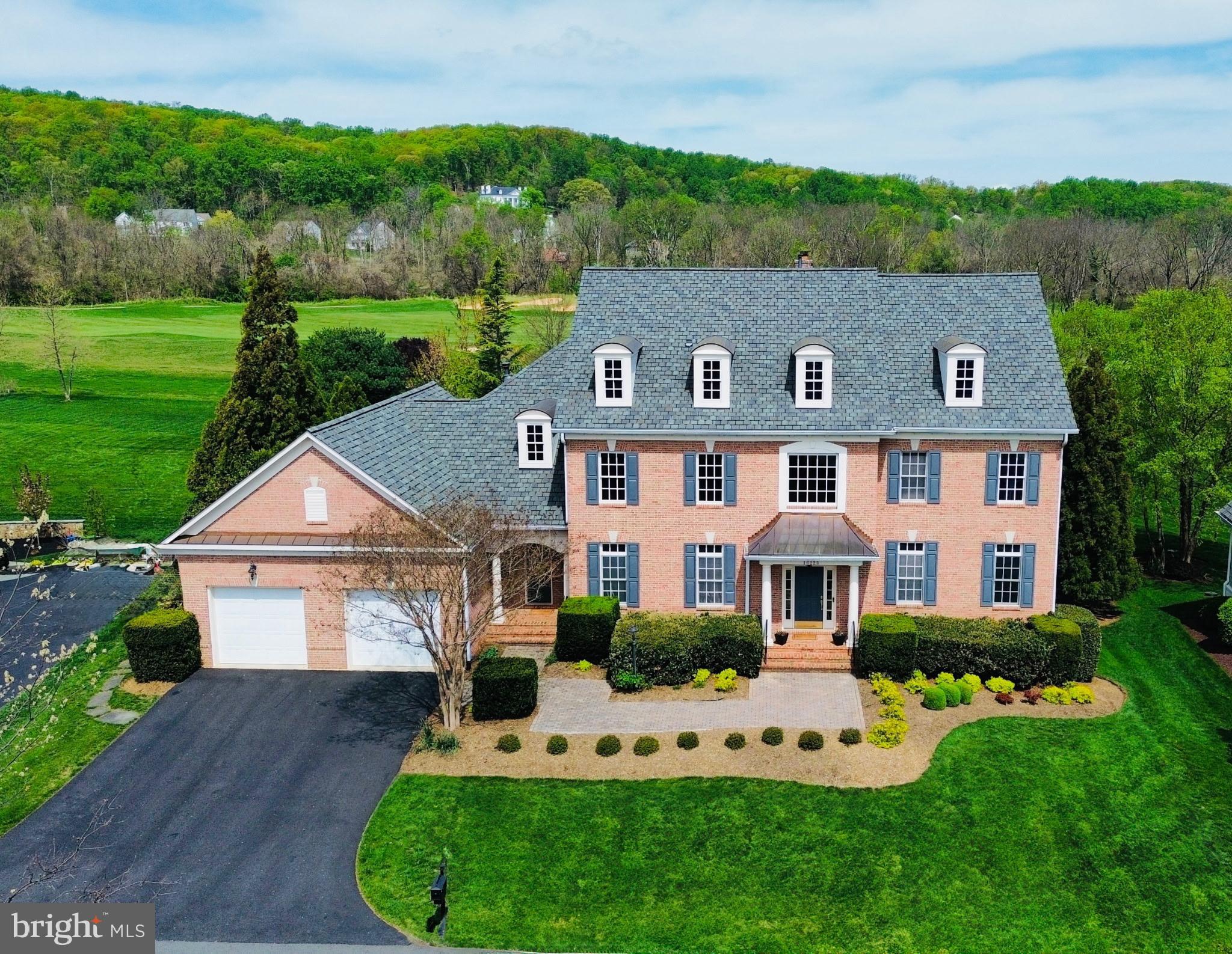 A masterpiece of style and function, this beautiful home sits on one of the most beautiful and tranquil lots in sought-after Raspberry Falls. Backing to the 4th fairway of the Raspberry Falls Golf and Hunt Club, with rolling hills in the background, this residence offers over 7,100 sq. ft. of finished living space across three fully finished levels with beautifully curated hardscaping & plantings, plus space to park four cars tandem in the garage. 

The rarely available North Landing model by Marquis Custom Homes features unobstructed sightlines from the two-story foyer through to the large family room windows, showcasing stunning views of the golf course and rolling hills beyond. With 10-foot ceilings on both the main and lower levels, 8-foot interior doors, and extensive trim work throughout, every detail reflects the quality of this high-caliber home.

The gourmet kitchen is a chef's dream, equipped with top-tier stainless appliances including a Dacor double-wall oven, Viking professional refrigerator, Viking cooktop with range hood, Viking warming drawer, and Bosch dishwasher. The large center island is ideal for entertaining and casual meals. The expansive living room is perfect for hosting family holidays, while the cozy family room with a wood-burning fireplace sets the tone for relaxing evenings. A private rear office enjoys peaceful views of the expansive backyard and golf course.

Upstairs, the primary suite includes a sitting area that opens to a private Juliet balcony, a spacious walk-in closet with custom shelving, and a luxurious en-suite bath with dual granite vanities, a frameless glass shower, and soaking tub. Each of the secondary bedrooms is generously sized, all with en-suite baths featuring granite vanities and tile flooring.

The walkout lower level boasts 10-foot ceilings and full-size windows that flood the space with natural light. Highlights include a welcoming recreation room with a gas fireplace, an open billiards area, a mahogany wet bar with glass shelving and built-in lighting, and a walk-in wine cooler. A dedicated home theater includes built-in surround sound, HD projector, and screen. A fifth bedroom, stylish full bath with Carrara marble vanity, and a large gym with mirrored walls complete this level.

Outdoor living is exceptional, with a low-maintenance composite deck off the kitchen, a flagstone patio with a recessed firepit and natural stone seating, and a second patio nestled beside a tranquil multi-tiered water feature. The lush, deep backyard includes a natural buffer with milkweed that attracts monarch butterflies, goldfinches, blue jays, and cardinals. The home sits on a quiet circle bordered by common area for added privacy and beauty.

Located in Northern Virginia's premier golf course community, Raspberry Falls—a hamlet-style community of smaller neighborhoods separated by green spaces and the award-winning Gary Player-designed golf course—residents enjoy wide-open views, mature landscaping, a community pool, tennis courts, and a welcoming clubhouse. All just 10 minutes from downtown Leesburg, 8 minutes from Ida Lee Park, and 30 minutes to Dulles International Airport—right in the heart of Loudoun’s wine and brewery country!