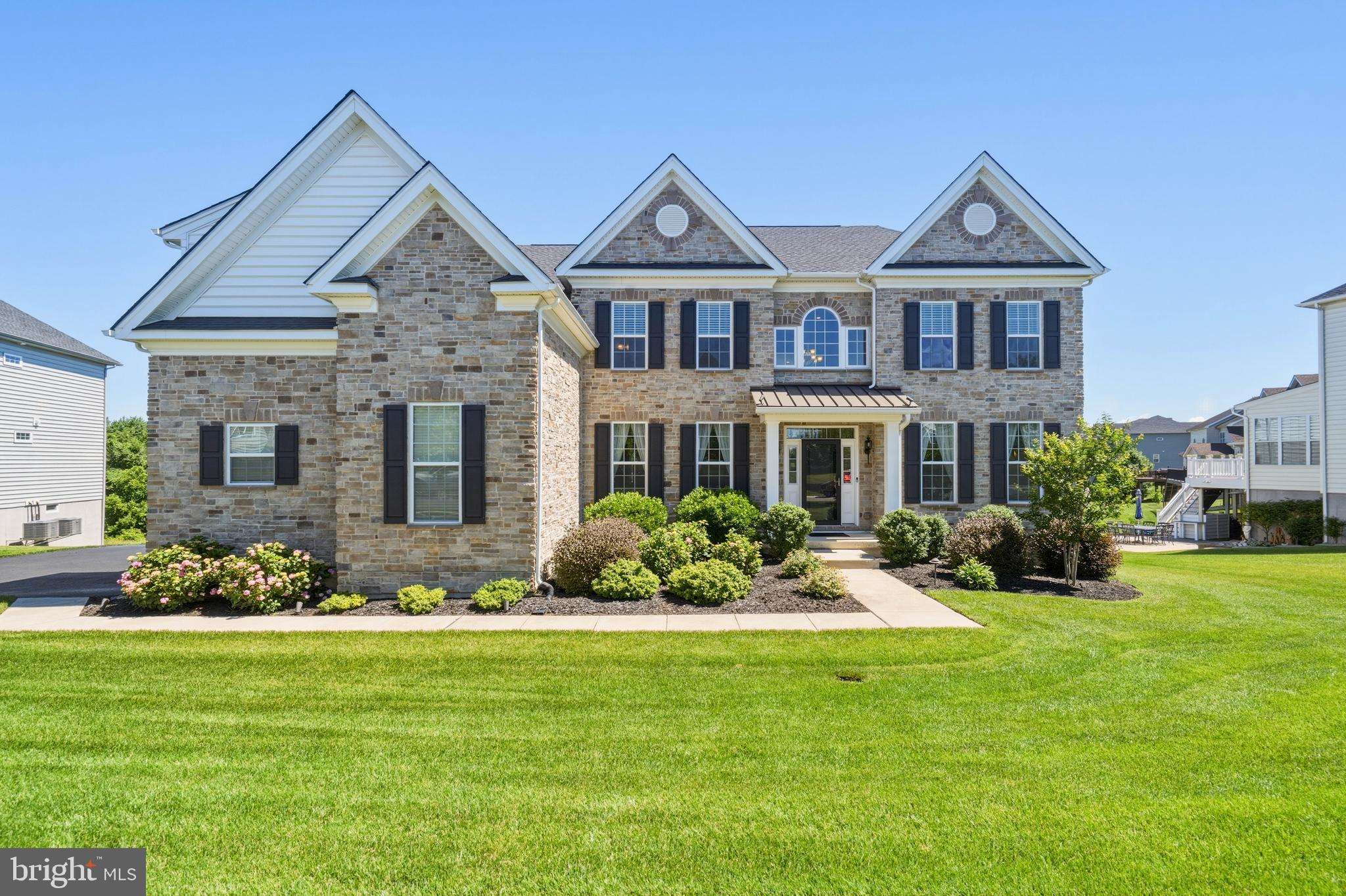 Welcome to 1030 Matthew Way, an extraordinary Toll Brothers Langley II estate nestled on a premium third-acre lot in the upscale Highpointe at St. Georges community. Spanning approximately 6,600 square feet across three finished levels, this architectural masterpiece offers an unmatched blend of luxury, thoughtful design, and everyday functionality. From the moment you arrive, the side-entry three-car garage with an electric vehicle charger and sweeping curb appeal set the tone for what awaits inside. Step through the grand two-story entrance foyer to soaring ceilings, gleaming engineered hardwood floors throughout most of the main level, and a stunning two-story family room anchored by a magnificent Palladium window that floods the space with natural light. Triple and double shadow box millwork frames the formal living and dining rooms with timeless elegance. The oak staircase and Colonial trim package, complete with crown molding throughout speak to the craftsmanship that defines every corner of this home. The thoughtfully designed kitchen is a chef's dream, appointed with granite countertops, 42-inch wall cabinetry, stainless steel appliances, a ceramic tile backsplash, and two pantries for exceptional storage. A back staircase off the kitchen provides seamless access to the upper level, ideal for busy household flow. The breathtaking solarium retreat is a true showstopper, offering 180 degrees of panoramic tree views through walls of windows on three sides beneath a soaring vaulted ceiling with recessed lighting. Currently enjoyed as a game room, this one-of-a-kind space is tucked adjacent to the garage. Just a few steps away from the deck on the main level, this space seamlessly blends indoor luxury with the beauty of the natural surroundings. There is simply nothing else like it on the market. The main level also features a full bedroom and bath, perfect for guests or multigenerational living. Upstairs, the sprawling primary suite is a private resort unto itself, boasting three closets, a dedicated dressing area, and a sitting room. The spa-caliber primary bath features radiant heated floors, an oversized Jacuzzi whirlpool soaking tub, and a water closet, delivering the ultimate luxury experience. Two additional bedrooms share a well-appointed hall bath, while the princess suite has its own private ensuite and walk-in closet. The walk-out lower level is equally impressive, offering approximately 2000 finished square feet that includes a library and study, a full fifth bathroom, a workshop, and abundant storage, all illuminated by full-size windows that bring in natural light. This space was partially finished during original construction and completed to the same high standard in 2023. Additional highlights include a 15 by 21 rear deck, a second deck, and a patio for seamless outdoor entertaining, complemented by a full irrigation system on the approximately one-third acre lot. The home is equipped with 400-amp electrical service, three HVAC systems across four zones for precision climate control, and all the quality assurance and energy efficiency features Toll Brothers is renowned for. This is Delaware luxury living at its absolute finest.