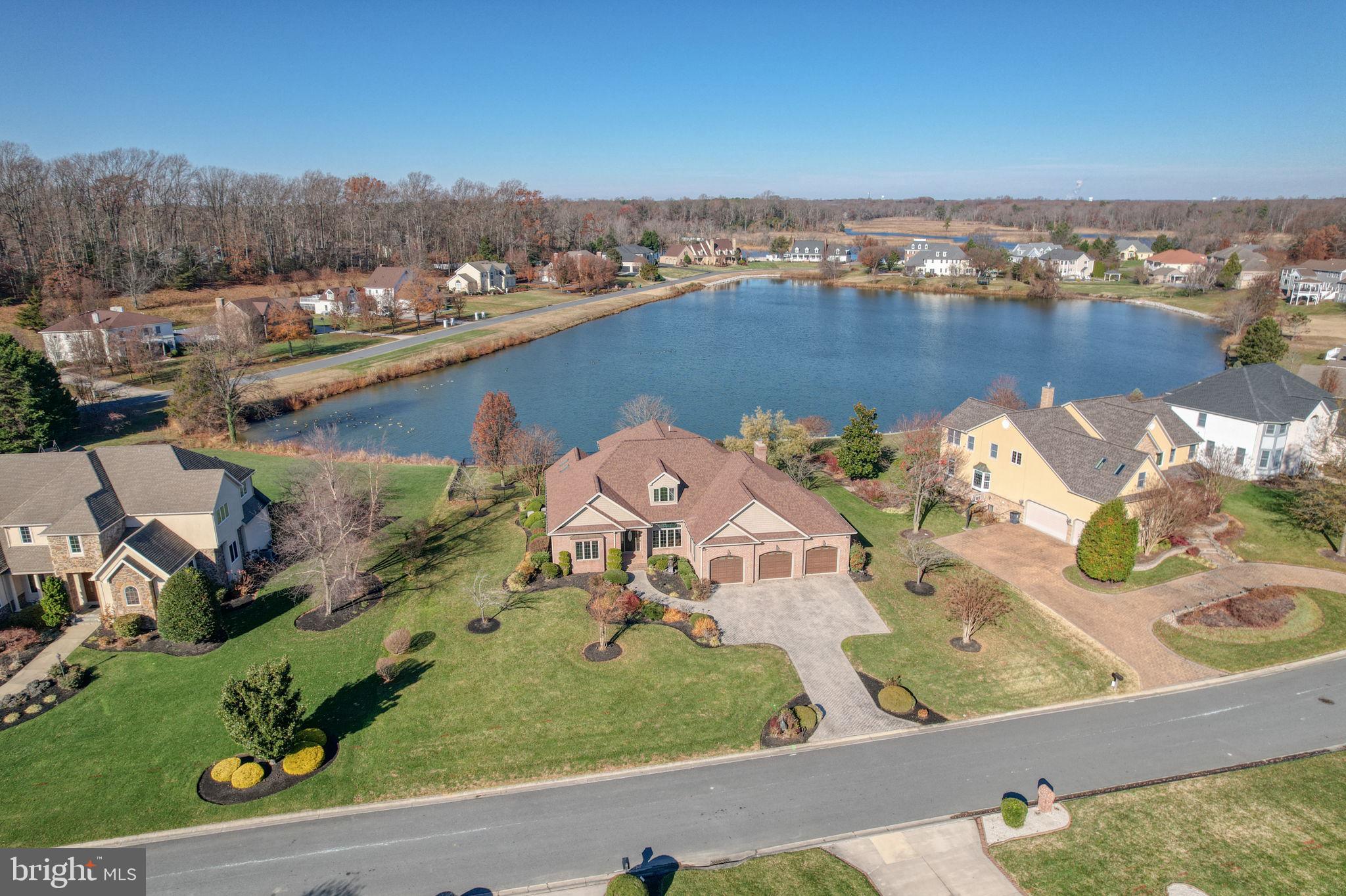 Waterfront in Windswept! Every detail of this all brick home, located in the most highly coveted Windswept neighborhood in the Caesar Rodney school district, has been crafted to showcase breathtaking pond views and luxurious living. From the moment you enter, walls of expansive Andersen windows frame the water, flooding each room with natural light and creating a serene backdrop that changes beautifully with the seasons. The home  flows seamlessly into elegant dining and living spaces, opening directly to a screened porch that feels like your private retreat—perfect for savoring morning coffee or evening wine while overlooking the water.
The gourmet kitchen is a chef’s dream, complete with upgraded appliances, a generous pantry, and a breakfast area designed to capture the view. An inviting family room with a striking gas fireplace with surround stone detail offers warmth and charm during cooler months. The main level also features a large office with custom built‑ins and skylights, laundry room, and an oversized three‑car garage with abundant storage. The luxurious primary suite is a true sanctuary, boasting a spa‑like bath with soaking tub, separate shower, and expansive walk‑in closets. An additional bedroom with attached full bath, and powder room complete the main floor.
Upstairs, two spacious bedrooms, a full bath, and a spacious loft  provide the perfect retreat for guests or family. Outdoors, the covered screened porch leads to a brick patio with a built‑in natural gas grill and hot tub - perfect for resort style relaxation at home . The meticulously landscaped yard, enhanced by an irrigation system, frames the shimmering pond, where waterfowl, flowering trees, and summer reflections create a living masterpiece year‑round.
This home is not only stunning but also exceptionally well‑built, with premium features including a new roof,  new carpet throughout, gas‑fired generator, three‑zone HVAC, an encapsulated crawl space, and endless storage. Very rarely does a property combine such craftsmanship and natural beauty in a prime location .  Schedule your tour!