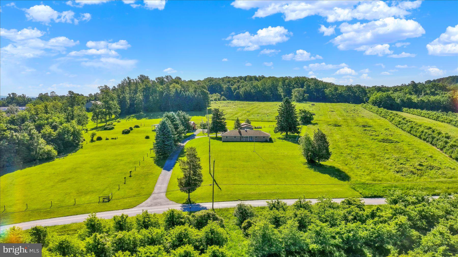 Lewisberry retreat on 7.45 acres!!!  Located in a peaceful rural setting, right around the corner from Mt. Airy Orchard and less than a mile and a half from Roundtop Mountain Resort! This property is a rare opportunity to own a turnkey homestead and acreage including a ranch style home, 4 fenced acres, a climate‑controlled 1,000 +/- sq ft outbuilding, a fully equipped horse barn and more! This property delivers the perfect blend of comfort, rural tranquility, and functional space for hobbyists, equestrians, or anyone seeking a true country lifestyle without sacrificing convenience. The home features 2,050 sq ft of finished living space, including a main level with an updated kitchen, three bedrooms, including an owner’s suite with its own full bathroom and a HUGE great room (with its own HVAC system) that boasts ample natural light, bar area and views of this property to the rear! The lower level adds flexible space and includes plenty of storage, a true game room and laundry area. Step outside and you’ll find everything needed for outdoor living including a peaceful rear porch, fenced yard, wide‑open views, mature trees, and room to roam.
The outbuildings include a 1,000 +/- sq. ft. climate controlled one-story building with its own HVAC system, one bay garage style entry and separate dual door access. This building offers endless possibilities, ideal for a workshop, studio, car storage, or small business operations   Next, the horse barn which includes a concrete floor, 200‑amp electric service, water service, tack room, and three well‑designed stalls ready for your equestrian needs.  Schedule your showing today!