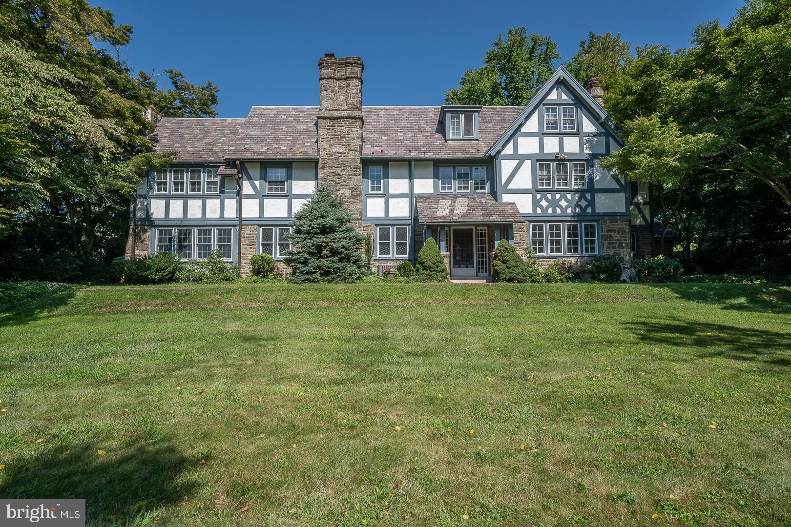 This home personifies Main Line architecture with the character and details updated with modern amenities. From the moment of entry, you can't help but notice the sun illuminating the house. Then focus on an elegant staircase and French Doors  both to the right and left sides of the foyer that lead to the Living and Dining Rooms. Both rooms have large, elegant fireplaces; one has marble framing, the other brick. The Living Room and Dining Room are overly spacious - great for entertaining. From the living room, another set of French Doors lead to the Family Room with a third fireplace. This room has an abundance of book shelves  and extends to an additional space. This space has built- in cabinetry for a TV, skylights, and glass doors leading to a  patio,  grounds, and swimming pool. The kitchen is fully equipped with a double-wall oven,  dishwasher, built-in refrigerator, a large sink, auxiliary sink, a large walk-in pantry closet with cabinetry, counter, and a large island that accommodates seating.  There is a Powder Room and coat closet on the 1st floor.  The approach to the 2nd floor is one of the highlights of this home. The leaded glass windows on the landing are truly beautiful.  The Main Bedroom on this floor adjoins a  spacious sitting/dressing room with  yet more closet space. The Main Bedroom also has a full bathroom with a double sink, a soaking tub, and separate walk-in shower. The 2nd and 3rd Bedrooms have ample built-ins such as drawers, closets, shelving, and desk.  Also on the 2nd floor is a 4th bedroom with open and enclosed shelving. A full bath with tub/shower is also on the 2nd floor. Ever wish for a second-floor laundry? Yes, it's here! The 3rd level has an open landing with  another wonderful large 5th bedroom and additional 6th bedroom. Here we have a bonus room with  two  built-in desks along with another wall of enclosed cabinetry. A walk-in storage closet and walk-in attic is also on the 3rd level.  The lower level is partially finished with a very large pantry room, and two all-purpose rooms with an enormous amount of additional storage space.  There is also a large two-car garage with stairs to a 2nd level.  Beautifully landscaped plush grounds are the backdrop of a perfectly placed swimming pool that offers total privacy.  Enjoy outdoor entertaining  on the patios. The entire perimeter of the property is surrounded by greenery. Take the opportunity to live on a  beautiful quiet street in a walkable neighborhood with sidewalks. The convenience of the Main Line train, R-5, gets you into Center City in less than 20 minutes. **A list of owners' improvements is available. Square footage may not reflect 1st floor addition.