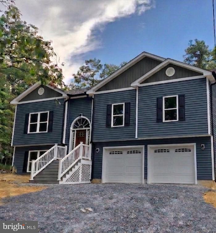 Welcome to your future dream home! New construction with time to make some of your own choices! This beautifully designed split foyer blends modern living with classic comfort. Situated on a spacious almost 1/3-acre lot, this 1909 square foot home offers plenty of room to grow, relax, and entertain—inside and out. The front porch offers graciously wide steps and vinyl railings, setting the expectation of quality craftsmanship outside and in. Stepping inside, high expectations are exceeded as you experience the 9'-ceilings and inviting open-concept layout, where the living room, dining area, and kitchen flow seamlessly together—ideal for gatherings, daily living, and everything in between. Natural light pours through energy-efficient windows, highlighting high-quality finishes and thoughtful design throughout including upgraded trim and lights. The upper level boasts a spacious primary suite with a full bath, plus two additional bedrooms and another full bath. Downstairs, a fully finished lower level features a large bonus living area/4th bedroom and another full bath—perfect for a home office, guest suite, or rec room. The kitchen comes complete with granite tops and upgraded cabinetry featuring soft-close doors and drawers. Bathrooms also enjoy granite tops and tile showers. Additional highlights include durable and stylish vinyl plank flooring throughout main areas and primary bedroom. a generously-sized two-car FINISHED garage, and a level lot with room for outdoor living, gardening, or play. Located in Shawneeland, a community that offers a number of mountain lakes, playgrounds, picnic areas, volleyball, baseball and basketball courts. Quiet and secluded but easy and convenient access to local amenities. Whether you're looking for your first home or your next chapter, this brand-new split foyer offers functionality, flexibility, and fantastic value. Don’t miss your chance to personalize finishing touches—schedule a tour or consultation today!