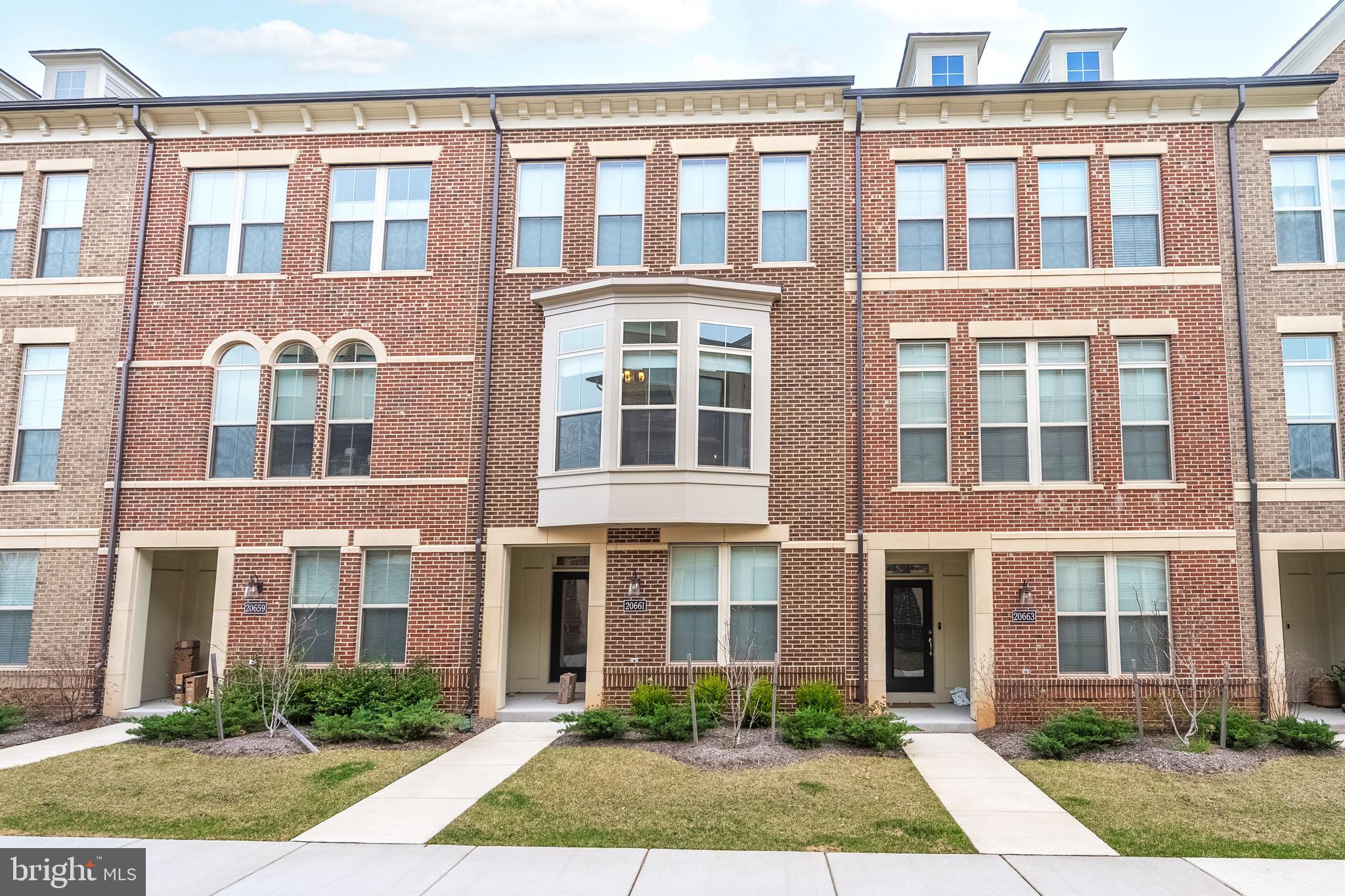 Welcome home!!! Don’t wait to build, when this beauty is Available Now **** This 3 level, brick front Interior townhouse – Miller & Smith Gabrielle Model. Built 2022 is ready for you! It is conveniently located for shopping & entertainment within walking distance of the Main town center area of One Loudoun. Close to outdoor events including seasonal “The Barn at One Loudoun with its amphitheater and Barn"!  Near commuter routes, Route 28 & Route 7. Close to Dulles Airport & INOVA Loudoun Hospital Center. Coming into your future townhouse, you can either enter through your attached two car garage with Electric plug set up for Car Charger, in the rear of the townhouse, or in front, where it has a walk in level with Bedroom & full bathroom – this is ideal for au-pair area. Whichever path you choose coming into this traditional townhouse, the stairs will lead you to a gourmet kitchen, which is ideal for entertainment, featuring granite counter tops, Built in Microwave & Wall oven, Stainless steel appliances, kitchen island & with touch faucet sink. Large Family room area on one side of the kitchen, This leads you out to the Balcony,  which is peaceful and great for relaxing and unwinding from the day and the other side is a dining area. Before you make your way upstairs to the bedroom level, Don't miss the half bath powder room. Upstairs there are 3 additional bedrooms and 2 full baths. Both bathrooms upstairs have Dual Vanities. The  Primary Bedroom has extra light, a walk-in closet & a tray ceiling. The laundry room is also upstairs for convenience. Flat screen TV in family room to convey. You won't want to miss this opportunity!
