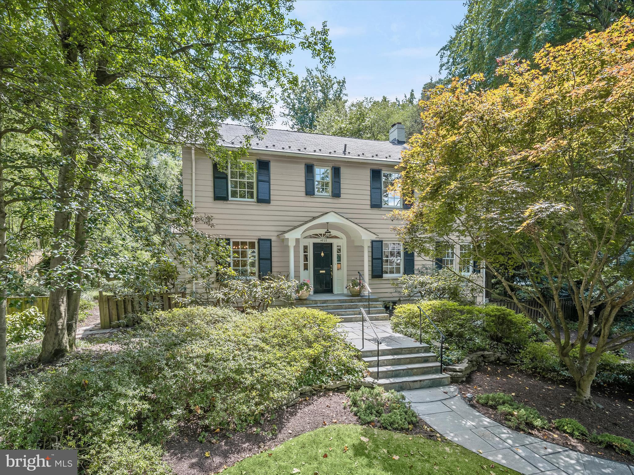 This captivating colonial home, brimming with grace and character, is set back from the street on a beautiful half-acre lot surrounded by tall, majestic trees. The property features a spacious, private backyard and sunlit rooms throughout. Located on the sought-after Cumberland Avenue in the historic village of Somerset, this charming colonial, built in 1925, has been meticulously updated over the years. It boasts period details, a center hall, a gracious dining room with wainscoting, a chic updated kitchen/family room that opens to decks and a garden, a bright stately living room with a fireplace, a sunroom/study with windows on three sides, and gleaming hardwood floors throughout.
Upstairs, three cheerful bedrooms await, including a hall bath and a master bedroom with a sitting room and bath, as well as a private deck overlooking the backyard. Newly carpeted stairs lead down to the partially finished basement, which includes a recreation room, a large storage closet, a utility room, a laundry room, and access to the one-car garage.
The grounds are an absolute delight! The home is set back 70 feet from the street, offering both front and back yards that provide privacy and beautiful views. There are ample opportunities for children to play and for serene outdoor dining in this magnificent setting.
The Town of Somerset, established in 1907, is a close-knit community with its own private swimming pool, tennis courts, and town hall, as well as its own mayor and town council. Somerset Elementary School, tucked away on a quiet street, has been known for academic excellence for decades.
A short, scenic stroll takes you to the Capital Crescent hiking/biking trail and Norwood Park. The home is also a short walk to fabulous Friendship Heights, with its red line Metro stop, shops, and restaurants. This wonderful offering truly captures the best of all worlds.