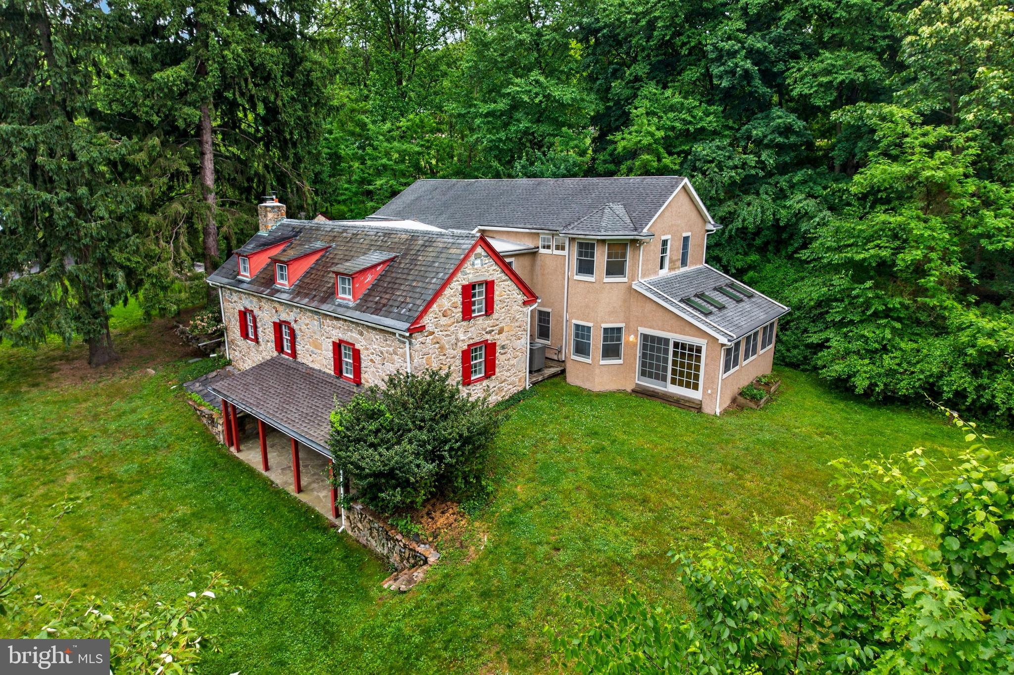 Step into the timeless beauty of 2 Wyndham Hill Dr, where historic character and everyday comfort come together on 3.49 picturesque acres. Originally built in 1827, with a rich history. This remarkable stone farmhouse offers over 3,600 square feet of living space surrounded by peaceful scenery, mature landscaping, with an abundance of flowering trees and plants. and the kind of privacy that feels like your own countryside retreat. 
As you arrive, you’ll immediately appreciate the charm and versatility of the property, featuring a private pond, classic stone summer kitchen, oversized detached garage, spacious 2-story bank barn, and additional covered parking with a carport. Whether you dream of entertaining guests, enjoying quiet evenings outdoors, or simply escaping the pace of everyday life, this property creates a setting you’ll look forward to coming home to.
Inside, you’re welcomed by an oversized foyer with rich walnut wood paneling and generous closet space, perfect for a functional mudroom or warm greeting area. The heart of the home is the expansive eat-in kitchen, where beautiful natural wood shaker-style cabinetry blends seamlessly with updated stainless steel appliances including a refrigerator, dishwasher, built-in microwave, and range. A kitchen where everyone can gather. 
The home’s character continues throughout the spacious dining room and inviting formal living room, where exposed beams, original hardwood, wood beaded paneling, built-in shelving, cabinetry, and a fireplace highlight the original charm of the farmhouse. Impressive 20x18 sun-filled great room with spiral staircase and handsome wainscotting offer flexibility for the way you live today, picture mornings filled with sunlight and coffee in this great room, while overlooking the surrounding property. Also a first-floor office, cozy den or optional bedroom, with original hardwood and a large full bath.
Upstairs, the private primary suite provides a peaceful escape with its own newly renovated bathroom, walk-in closet, and access to a private deck and walkway where you can enjoy the beauty of the grounds in every season. Three additional bedrooms, a full bath with stylish tile floor and new vanity. A laundry room you can really work in, complete with a utility sink and bonus flex space perfect for a playroom, studio, reading nook, or additional office complete the second floor.
Outside, the expansive acreage invites endless possibilities — from gardening and recreation to gatherings under the stars next to the fire pit. The barn, garage and car port provide so many opportunities; a small farmette with chickens or maybe a few goats, large parties, contractors that need equipment storage,  or just store all of your treasures! Full basement., new section has radiant heat flooring.  Lennox  A/C heat pump  2023, Oil boiler, water pressure tank 2020. Water treatment rebuilt in 2020. Transfer switch for generator. All of this is conveniently located close to schools, shopping, dining, and major highways, giving you the perfect balance of privacy and accessibility.
Come experience the warmth, history, and beauty of this one-of-a-kind property and discover why it feels so much more than just a house.