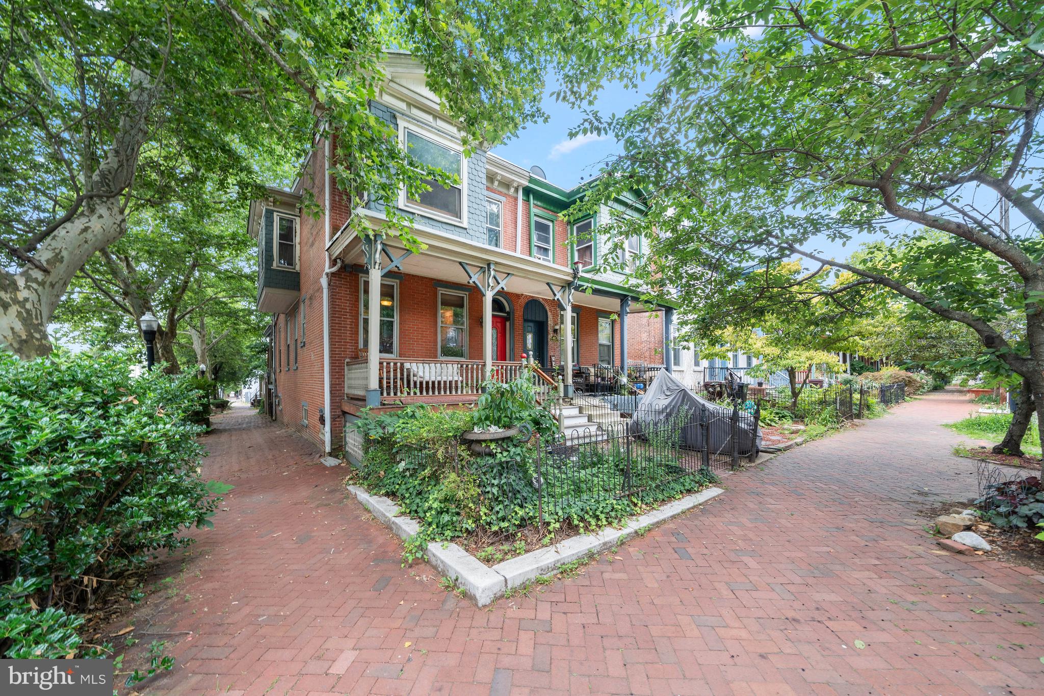 Classic character and incredible opportunity in the heart of Wilmington!  Welcome to 800 W 10th Street, a brick twin home bursting with architectural integrity, unique textures, and rare features that are hard to find in urban living. From the moment you approach the welcoming front porch, you’ll recognize the value this home offers. Step inside to an expansive, open-concept living area highlighted by authentic wide-plank wood flooring, a dramatic fireplace surround, and a stunning exposed brick accent wall. The seamless flow leads you to the dining area and into the kitchen rich with rustic texture, featuring stone island accents, warm wood cabinetry, and stainless steel appliances. Laundry and a full bath are located on the main level.  Upstairs, the home continues to showcase its historic roots with generous room sizes, classic, warm radiator heating, and distinctive wall paneling. An additional den or home office space boasts another exposed brick feature wall, offering a cozy retreat or a perfect creative workspace. A full bathroom with a glass-enclosed shower serves the upper level. Step outside to a private, fenced-in rear deck—an urban oasis perfect for weekend BBQs, container gardening, and outdoor relaxation. Best of all, say goodbye to the city parking hassle: this home includes its own attached garage, a premium commodity in Wilmington! Perfect for a savvy homeowner or investor looking to capture a piece of the city. Schedule your tour today!