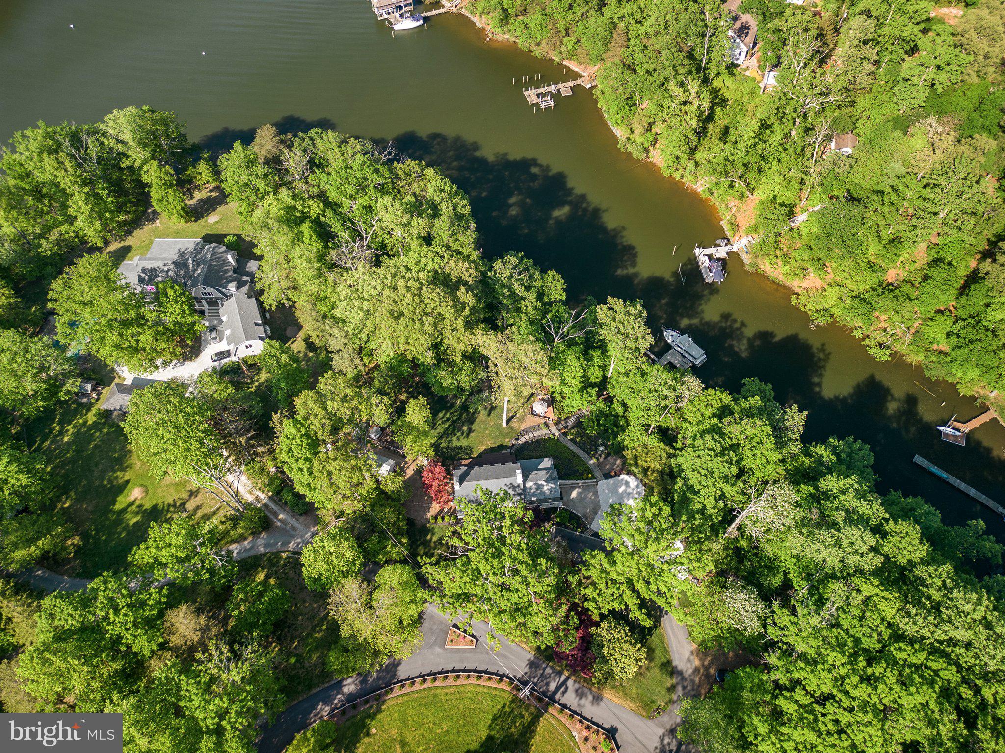 Private waterfront retreat...Enjoy wonderful water views of Luce Creek throughout the home. Located on nearly two serene acres just minutes from Downtown Annapolis, private waterfront estates like this do not come along often. Completely renovated from top to bottom, this gorgeous home maintains original character and charm with all the modern conveniences of luxury living.  From the welcoming & wide front porch perfect for porch to the open concept main level maximizing every waterside view- you will love each thoughtful update allowing you to escape the busy world and relax in your own personal retreat.  Designer lighting, custom wall paper and neutral paint, charming dutch doors, farmhouse black Andersen windows, gorgeous hardwood floors plus a gourmet kitchen fit for a chef with white marble backsplash, quartz counters & white shaker cabinets and a large 5+ person center island.  Entertain with family and friends hosting your favorite holiday in the large dining room with charming fireplace serving as a focal point.  Bring the guests outside to enjoy the beautiful gardens. Host summer barbecues on the large deck overlooking the water, sip cocktails on the private screened porch & enjoy evenings overlooking Luce Creek by your firepit.   Bring your boat to the private dock  for endless memories along the shores of the Severn River.  Lush landscaping and hardscaping all along the property.  The upper level is expansive, featuring 4 bedrooms, 2 full baths plus the laundry room. A third fireplace offers a cozy ambiance in the primary suite.  Both full bathrooms boast complete renovations with quartz counter tops, gorgeous Carrara flooring and new fixtures and lighting.  Travel to the lower level with a full basement offering garage access, and bonus rec space used as home gym, office and additional living area with ample storage and a rough in for an additional bathroom.  2 car side entry garage parking with plenty of additional driveway space. Home also features newer water treatment system, newer HVAC and updated electric and plumbing.  Easy commuter access & close to shopping, dining & entertainment- this one will not last long. Schedule your private tour today!