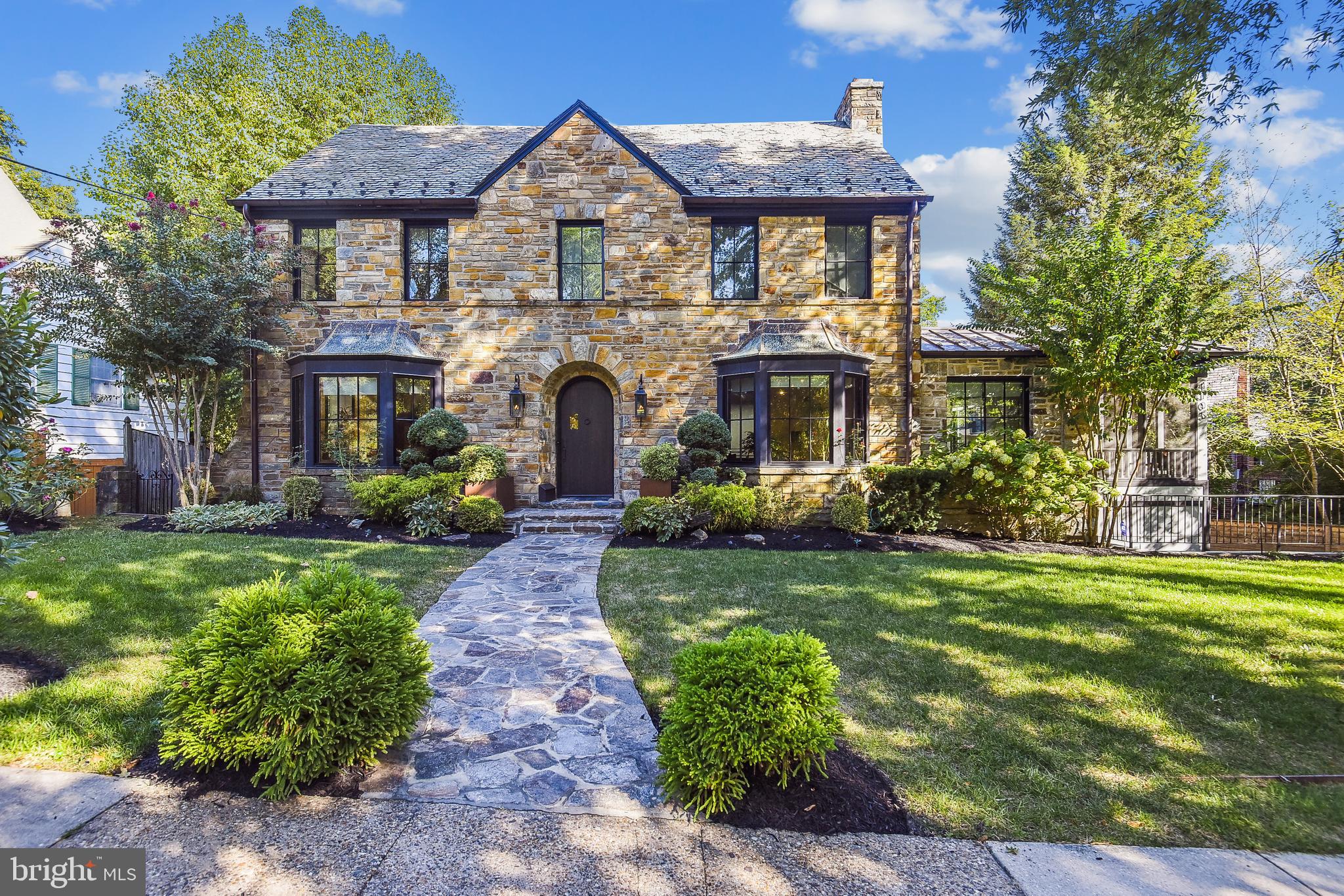 PRICE IMPROVEMENT! Stunning renovated modern industrial themed 5BR/4FB/2HB colonial with a three-car garage (one tandem) was completely gutted and designer renovated in 2017.  This stone front home with slate roof and Hardi-plank siding has maintained its old world charm with all modern amenities. The floor plan boasts approximately 6,000 square feet of living area on four levels including a great sense of light and spaciousness along with designer home appeal and quality craftmanship throughout. Original features of the home include several doors and stairs that were repurposed white oak from the barn columns, stain glass windows 10-foot and two-story ceilings.  Upgrades include all new Windsor Pinnacle Clad custom windows, new wide-plank White Oak veneer with dark distressed finish hardwood flooring throughout most of the entire home, designer Porcelain tile bathrooms, quartz vanities and kitchen with Miele appliances.  Inviting front stone walkway and manicured front yard leads to custom made solid Wormy Chestnut front door flanked by natural gas lanterns. Open foyer entrance featuring steel staircase and wood stairs (reclaimed from the original house).  Living room with bay window, wood burning fireplace with decorative wall surround and recessed lighting.  Separate office area with custom steel book shelves, skylights and access to screened-in porch.  Dining room with bay window and recessed lighting open to custom walnut kitchen with high end Miele appliances, Cambria quartz countertops and center island/breakfast bar with waterfall edge, and instant hot and cold-water dispenser. Breakfast area with second island with quartz countertops, recessed and pendant lighting and 52 bottle wine fridge. Great room overlooking lower level with gas fireplace, skylights, recessed lighting and access to balcony. Main level powder room with wall-to-wall Porcelain tile and flooring.  Hallway to lower level with access to second balcony and natural gas line for barbecue.  Upper level one features a spacious primary bedroom suite with gas fireplace, recessed lighting, laundry area with Miele washer and dryer, and his and hers walk-in closets with custom built-ins.  Luxury primary bathroom with two walk-in showers, steam sauna, soaking tub, custom cherry vanities with quartz countertops, heated floors, and balcony with privacy fence.  Two additional bedrooms (one en-suite) on the same level and full hall bath with walk-in shower. Fourth level loft area with bedroom, sitting room and half bath.  Two-story lower-level recreation room with breathtaking 10-ft 100-200 year old stained glass window and separate side entry way. Fifth bedroom with tray ceiling, custom built-in murphy bed, and side storage cabinets (will convey), recessed lighting and French door access to brick paver patio.  Second laundry area with LG washer and dryer, full bath with walk-in shower, media, and storage rooms.  Exterior features include multiple balconies, new brick paver patio and fully fenced-in backyard. The electrical system features all new panels, wiring and Legrand switches and dimmers with LED lighting throughout the entire home.  All new plumbing and high end Hansgrobe fixtures.  Two full gas air conditioning units and six zones with UV and additional filtrations plus humidifiers. Total house salt water softener and carbon filtration on the lower level. Bose sound system wired, and custom installed in all spaces will convey.  Conveniently located only .9 miles from the DC line and .7 miles from downtown Bethesda shopping and restaurants, nearby Chevy Chase elementary and Bethesda-Chevy Chase high school, Columbia County Club, local neighborhood parks and playgrounds.