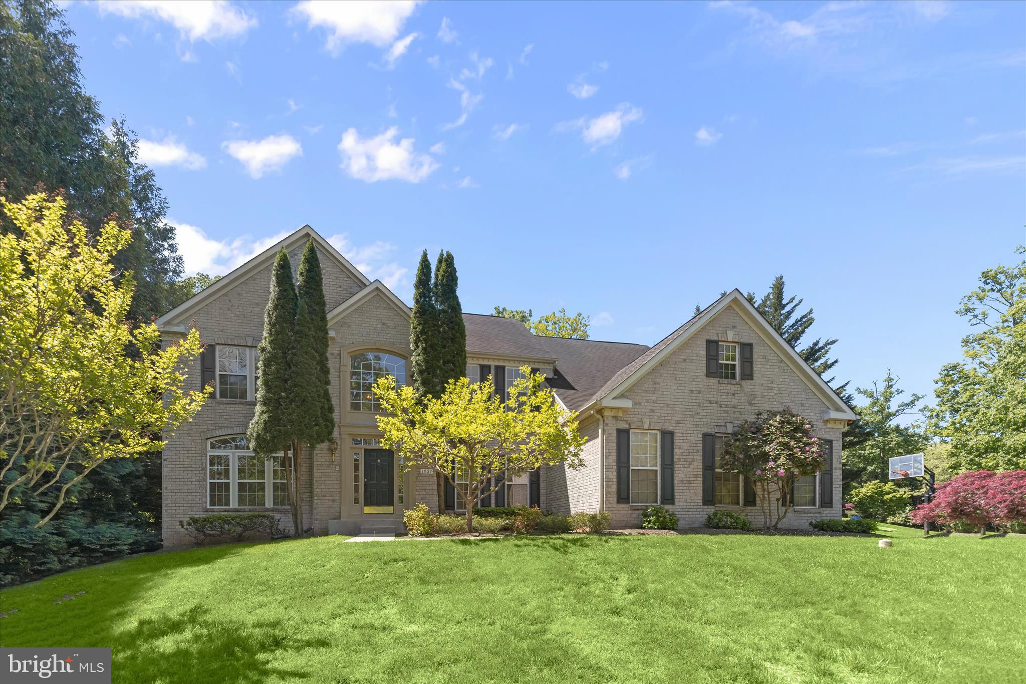 Located in sought-after Riggs Meadow, this beautifully maintained 5-bedroom, 4.5-bath Colonial is perfectly situated on a private 1-acre lot backing to trees and offers over 6,000 sq ft of living space designed for both elegant entertaining and everyday comfort. Thoughtfully updated throughout, the home welcomes you with hardwood floors and a dramatic two-story foyer accented by stately columns. The main level features a formal living room with crown molding and a sophisticated dining room with tray ceilings and a butler’s pantry, creating the perfect setting for gatherings and special occasions. The spacious gourmet kitchen is the heart of the home, complete with a center island, breakfast bar, granite countertops, and abundant cabinetry, all flowing seamlessly into the light-filled breakfast room. Just beyond, the impressive family room showcases soaring ceilings and a cozy fireplace, creating a warm and inviting atmosphere. Private office with French doors, laundry room, and powder room conclude the main level. Upstairs, the expansive owner’s suite offers a private sitting room, two walk-in closets, and a luxurious en-suite bath featuring a standalone soaking tub. Three additional bedrooms include a Jack-and-Jill bath and a private en-suite full bath, providing comfort and privacy for family and guests alike. The fully finished walkout lower level expands the living space with a large recreation room, wet bar, double-sided fireplace, additional bedroom, full bath, and ample storage space, ideal for entertaining or extended living. Outdoor living is equally impressive, featuring a spacious deck, fenced backyard, secure storage, and a peaceful tree-lined setting. Completing the home is a three-car attached garage and beautifully maintained grounds offering both privacy and functionality. This exceptional property combines timeless style, generous living spaces, and a serene setting in one of the area’s most desirable communities.