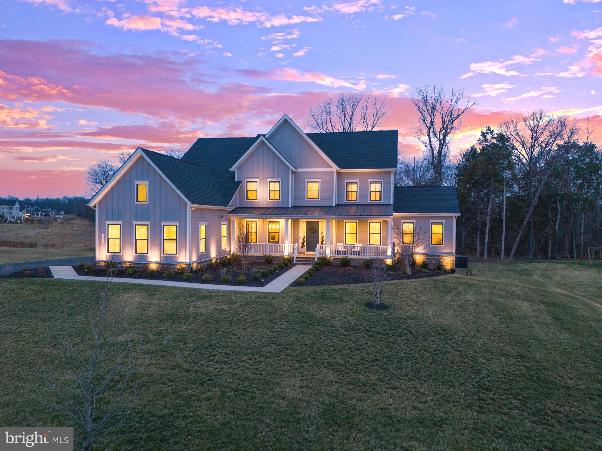 This stunning NV Clifton Park II model, completed in December 2022 and officially closed in 2023, is a true masterpiece, offering an unparalleled blend of luxury, comfort, and modern elegance. Nestled on a premium lot that backs into serene wooded views, this home provides the perfect sense of privacy and tranquility. From the moment you step inside, you are greeted by beautiful luxury vinyl plank (LVP) flooring that flows seamlessly throughout the main level, adding both durability and style. The grand entrance opens up to a formal living room on the right, ideal for intimate gatherings, while a spacious formal dining room on the left creates the perfect setting for hosting dinner parties and special occasions.

This thoughtfully designed home also features a main-level office, perfect for remote work or study, and a convenient half bath for guests. The heart of the home is the breathtaking two-story family room, showcasing exquisite coffered ceilings, built-in shelving, and a striking fireplace, creating an inviting space for relaxation and entertainment. Adjacent to the family room, the main-level bedroom offers a private retreat with a walk-in closet and an attached full bath, making it an excellent guest or in-law suite.

The gourmet kitchen is truly a chef’s dream, boasting two oversized islands that provide ample prep space and seating. High-end stainless steel appliances, all covered under an extended warranty, ensure peace of mind, while upgraded kitchen cabinets add to the space's elegance and functionality. Quartz countertops and a stylish backsplash elevate the kitchen’s aesthetic, while a separate coffee bar adds a touch of convenience. A prep sink is conveniently incorporated into one of the islands, providing added efficiency for entertaining. The casual dining nook extends the dining experience and leads directly to the screened-in porch, a stunning addition completed in 2024, allowing you to enjoy the outdoors year-round in comfort. Just off the kitchen, a well-appointed mudroom provides seamless access to the spacious three-car garage, ensuring a practical and organized entryway.

Ascending to the upper level, plush upgraded Berber carpet enhances the comfort and sophistication of the space. The luxurious owner’s suite serves as a private retreat, featuring a separate sitting area, a generously sized walk-in closet, and an owner’s bath that has been beautifully updated with high-end finishes. Three additional large bedrooms, each with its own attached bath, ensure that every occupant enjoys privacy and convenience.

The fully finished walkout basement is a remarkable extension of the home’s living space, designed for both recreation and relaxation. A large recreation room provides endless possibilities for entertainment, while a sleek wet bar with a quartz countertop makes hosting effortless. The dedicated media room is perfect for movie nights, and the gym room, newly completed in 2024, allows for convenient at-home workouts. Additionally, the lower level includes a full bedroom with a walk-in closet and an attached full bath, making it an ideal guest or au pair suite. An unfinished area provides ample storage space for seasonal items and more.

Beyond the stunning interiors, this home is further enhanced with an 11-zone sprinkler system added in 2023, ensuring lush landscaping year-round. Additional upgrades include a water softener and a furnace humidifier, enhancing comfort and air quality throughout the home.

Situated in the prestigious and highly sought-after Hartland community, this estate offers an unbeatable location. Residents enjoy close proximity to picturesque wineries, the expansive Hal and Berni Hanson Regional Park, top-rated schools, premier shopping and dining destinations, and major commuting routes, including Route 50, Loudoun County Parkway, and Old Ox Road. This home is truly a rare gem, offering the perfect balance of privacy, modern luxury, and unparalleled convenience.