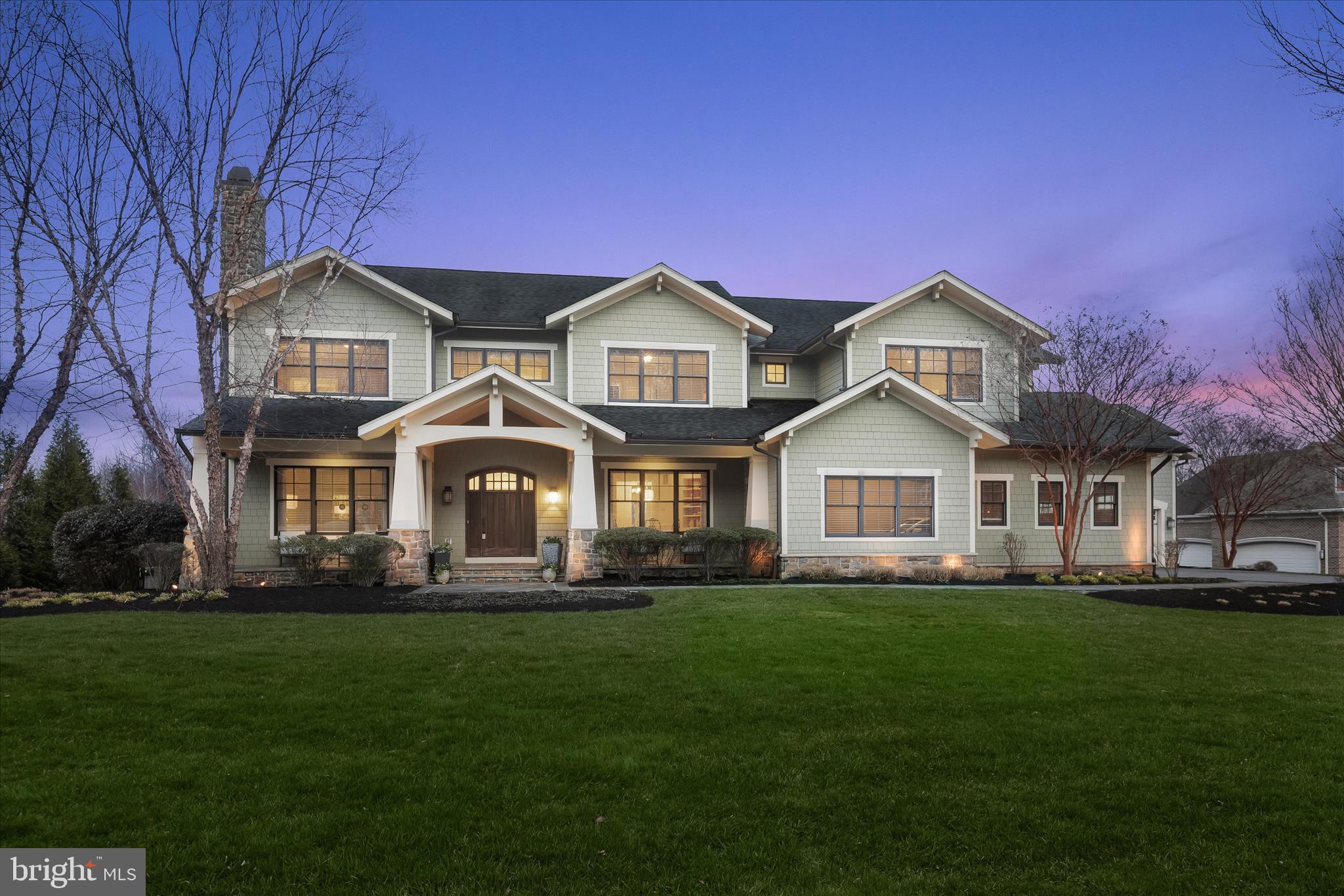 This exceptional custom Craftsman home by renowned Selfridge Homes blends timeless design, quality craftsmanship, and standout indoor-outdoor living.  A welcoming portico and front porch set the tone, while the backyard is truly next level, featuring a heated saltwater pool and beautifully designed, multi-tier outdoor living spaces with bluestone patios, an outdoor fireplace, and a built-in grilling area, all backing to expansive open space for added privacy. Inside, hardwood floors, detailed trim work, and thoughtfully designed spaces create a warm, elevated feel throughout. The gourmet kitchen is equipped with high-end appliances, a spacious walk-in pantry, and a casual dining area that flows seamlessly into a dramatic two-story great room with custom built-ins and a stone fireplace. Formal living and dining rooms offer classic entertaining spaces, while a private main-level suite with full bath and balcony adds incredible flexibility for a home office, guests, in-laws, or an au pair to complete the main level. Upstairs, the expansive primary suite features dual walk-in closets and a spa-like bath, while four additional bedrooms are generously sized with en suite or shared bath access. The finished lower level is designed for entertaining, complete with a custom bar, recreation and media spaces, theater room, full bath, and ample storage. A standout feature of the home is the private suite above the garage - offering a bedroom, full bath, and living space, ideal for an au pair, in-laws, older children, guests, or a quiet retreat of its own. Car enthusiasts, hobbyists and the everyday homeowner will appreciate the extensive garage capacity, including a four-car tandem attached garage plus an additional detached two-car garage.