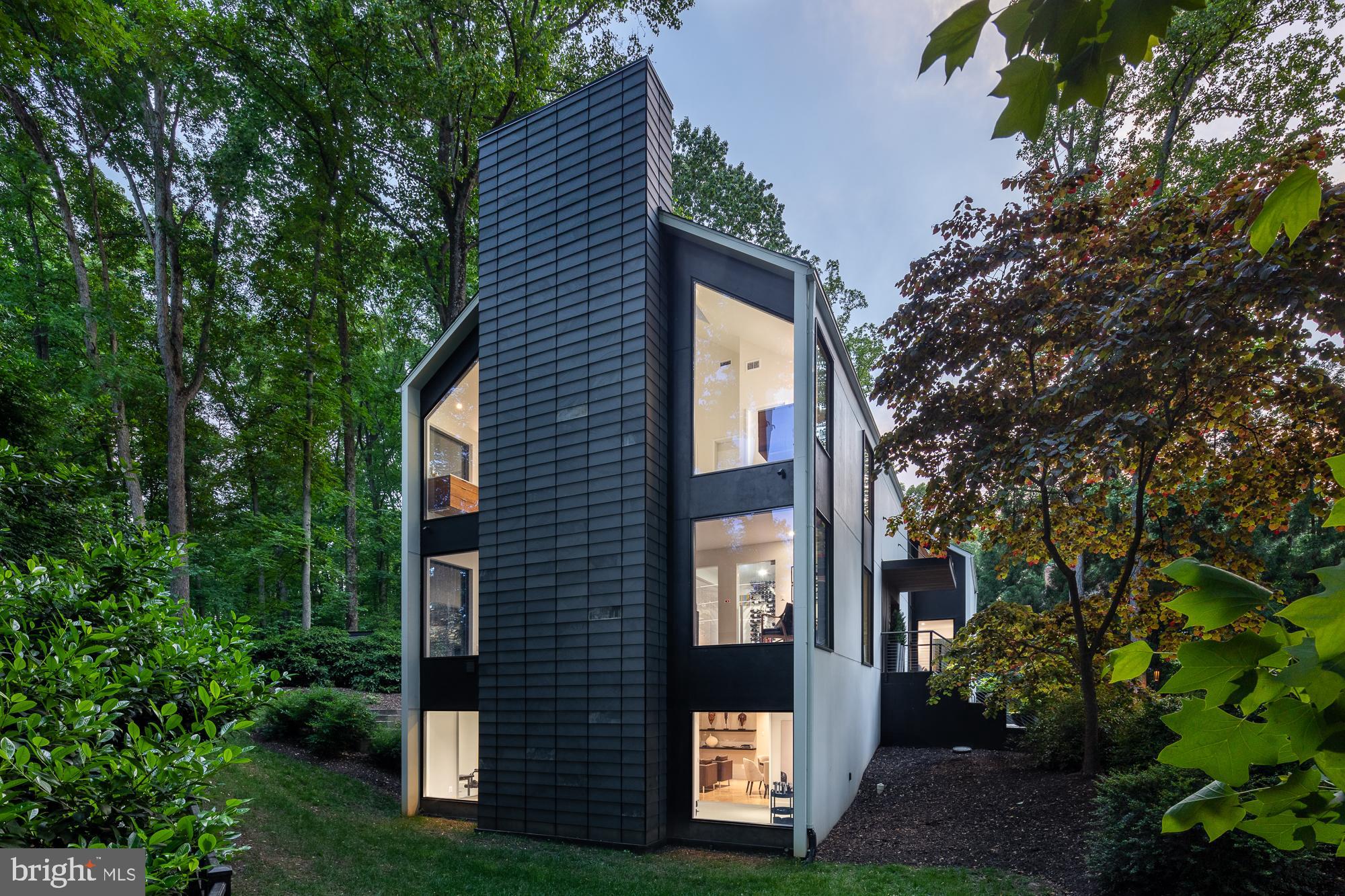 Positioned atop an expertly landscaped, 1-acre lot, this home - with complete renovation by Sagatov Homes in 2019 - espouses some of the most prominent ideals of modernism – simplicity, cohesiveness and purposeful orientation that pays homage to the natural surroundings. Uncompromising attention to detail is evident throughout. Soaring windows frame the tall trees and lush greenery, inciting a sense of excitement from the moment you step foot inside. The kitchen is light and welcoming. It features a large center island, parallel to the sizable window that overlooks the backyard, and an impressive array of high-end appliances purposely hidden in plain sight. The dual-sided fireplace creates an elegant divider between the kitchen and family room without closing off either space. Across the main level is a lively entertaining area that features a sleek and sophisticated bar, a climate-controlled wine room and a dining area with a beautiful gas fireplace. The primary bedroom on the upper level features a fireplace with gorgeous board and batten surround. The en-suite bathroom is vastly impressive, with heated floors, a dual-head shower, jet-soaking tub, separate vanities and separate water closets. A massive walk-in closet, a laundry room, three guestrooms and a guest bathroom complete the upper-level. The lower-level features an art-studio, a rec area perfect for lounging or playing games, a gym with direct outdoor access and lots of storage. An outdoor dining area off the kitchen with built-in grills as well as an oversized deck make for the perfect areas to unwind. This is an incredible offering of which our market seldom sees - a true modern home.