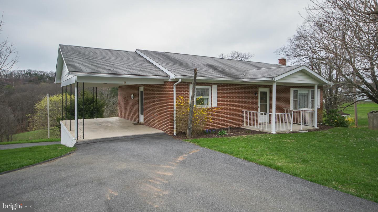 LOTS TO LOVE  with this three bedroom brick rancher on 5.21 unrestricted acres featuring a full walkout basement, paved driveway and parking, two carports, four stall tractor shed and open style barn small wet weather stream close to Historic Town of Bath, Berkeley Springs, WV..