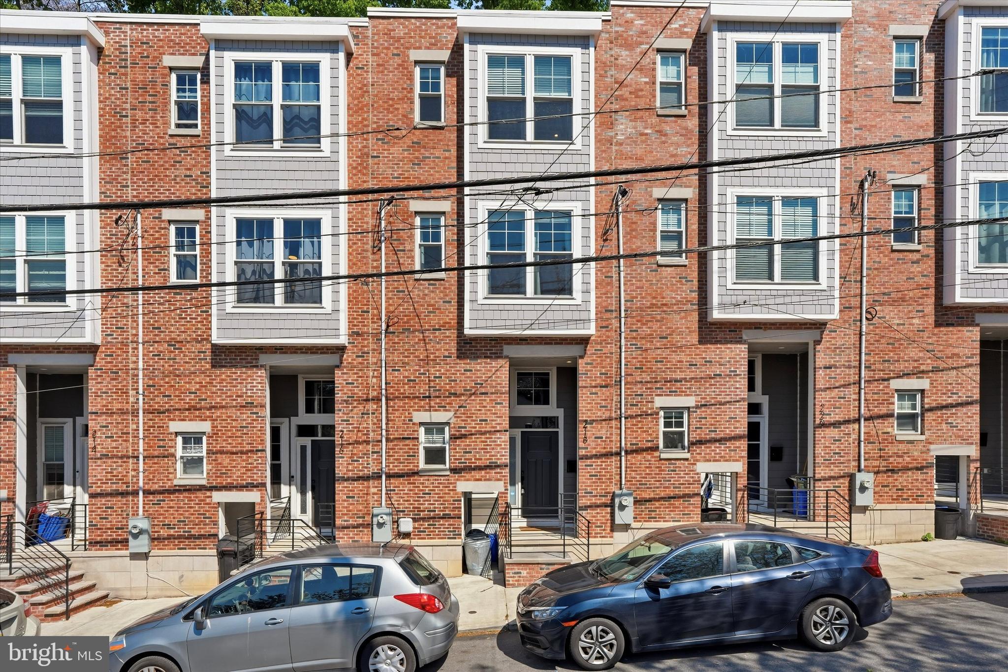 Welcome to 218 Fountain Street, a beautifully designed newer construction home in the highly desirable Germany Hill section of Roxborough/Manayunk , offering over 1,900 square feet of living space, a dedicated parking space, and a tax abatement in place through 2030.  Step inside to wide-plank hardwood flooring, high ceilings, and abundant natural light that carries throughout the open-concept main level. The living area flows seamlessly into a thoughtfully designed kitchen featuring soft-close cabinetry, leathered granite countertops, white subway tile backsplash, Samsung stainless steel appliances, and a large center island perfect for entertaining or everyday living. A dedicated dining area and tucked-away powder room complete this level. Just off the kitchen, the private rear patio provides the perfect setup for summer grilling, morning coffee, or unwinding at the end of the day. The second floor offers two spacious bedrooms, each with spacious closets, along with a well-appointed hall bathroom featuring a double vanity, tub/shower combo, linen storage, and a convenient second-floor laundry area. The entire third floor is dedicated to an expansive primary suite—your own private retreat. This level features two walk-in closets, a spa-like ensuite bath with dual vanities, an oversized walk-in shower with rainfall showerhead, and elevated tile finishes. Just outside the bedroom, a flexible bonus space is ideal for a home office or lounge area, along with a wet bar/coffee station and access point for a potential future rooftop deck. The finished lower level adds valuable flex space for a home gym, office, or media room, plus additional storage. Additional highlights include a sprinkler system for added safety, a covered front porch, and a dedicated parking spot, an essential amenity in this location. Ideally situated overlooking a park and just one block from the Hillside Recreation Center, residents enjoy easy access to a pool, playground, sports courts, and community spaces. All of this is just minutes from Main Street Manayunk, the Schuylkill River Trail, and major commuting routes including I-76 and SEPTA regional rail.