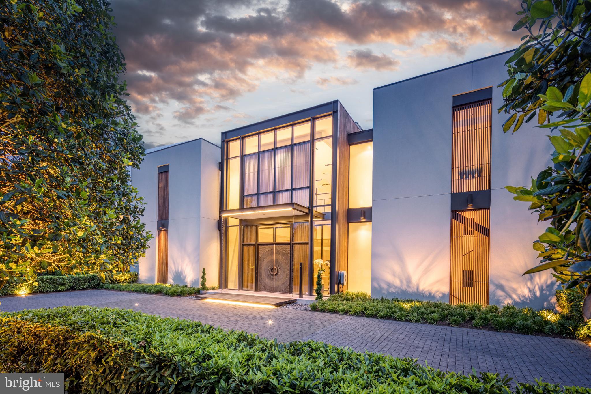MCLEAN'S GOLD COAST:  D.C. Metro-Area's most desirable landmark neighborhood. This custom residence, designed by well-known architect Mark McInturff and built by Added Dimensions Constructions, is exceptional in every way: design, construction, and finishes.  Concrete, steel & glass embody the symmetry that eludes European elegance to withstand the test of time. Natural light bathes 8,367 square feet of beautifully curated, conditioned interior space. The home offers convenient accessibility with an elevator from an expansive garage to all floors. A reception hall enhanced by bronze mesh sliding screens offers elegance and options for added privacy. With soaring 25-foot ceilings, the captivating Great Room sets a grand and sophisticated ambiance with radiant white limestone floors and a signature chandelier by Manooi, adorned with Swarovski Crystals. Skylights and floor-to-ceiling windows create an open and airy atmosphere. The gourmet kitchen features top-of-the-line Gaggeneau appliances, custom Boffi Italian cabinetry, and a European maritime-themed center island by Alno. The flooring combines high quality white oak, white limestone, with beautiful polished concrete in the heated garage. Technological innovation integrates seamlessly with automated lighting, audio, and video systems. Automatic shades and screens provide comfort throughout the home. Sustainability meets high-efficiency with hydronic radiant heating and a geothermal system. The spacious primary suite offers a sitting area, walk-in closets, and two luxurious baths with a soaking tub, fog-free mirror, and steam shower. The meticulously designed hardscape includes a travertine lounge patio with a gas fire pit and BBQ station, overlooking lush, parklike gardens and a picturesque creek. A saltwater, waterfall infinity-edge, heated swimming pool adds to the private oasis. Prepare to be captivated by a truly extraordinary home that redefines contemporary luxury and the highest quality at its finest.