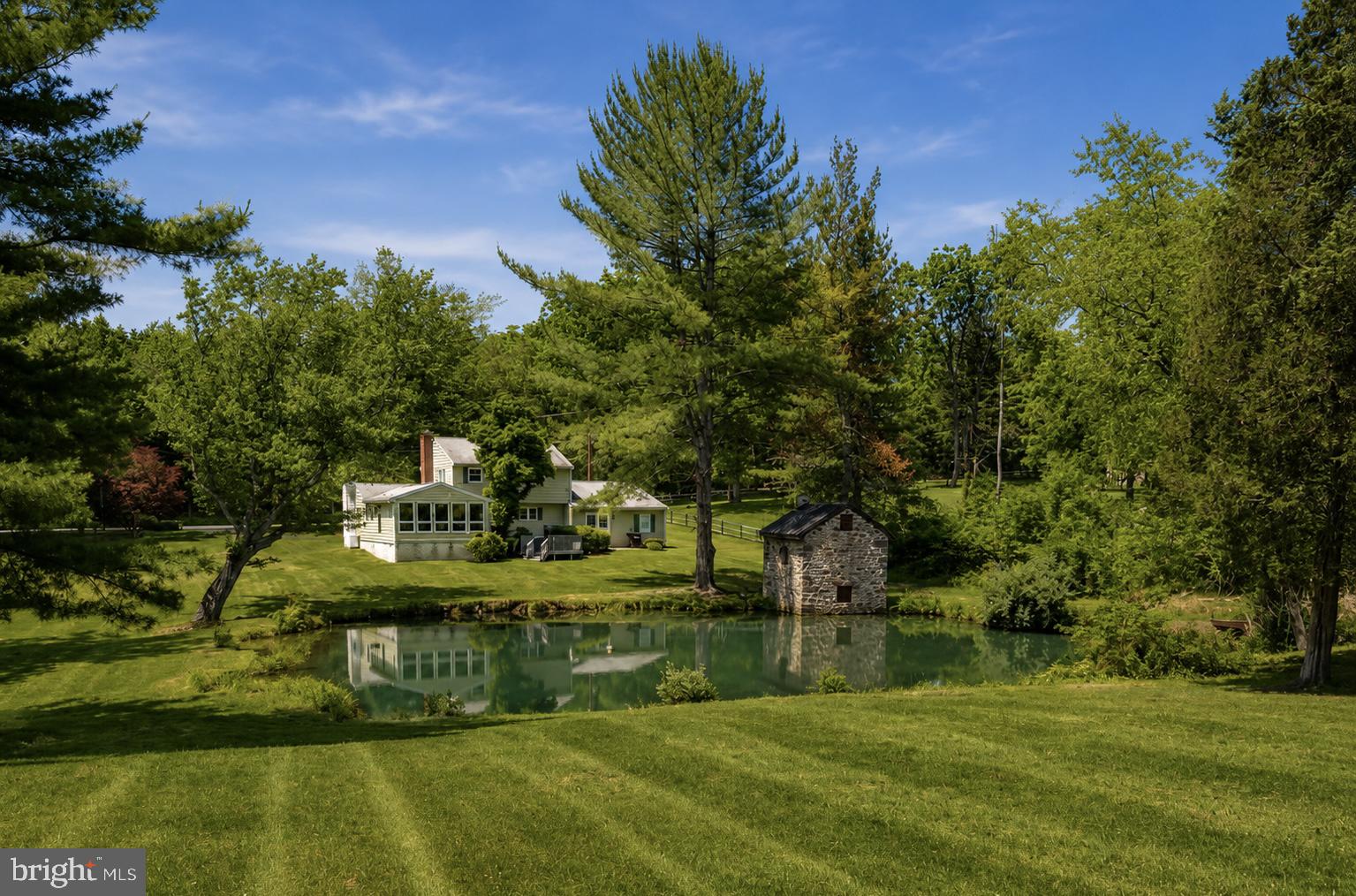 Welcome to 108 Sheeder Road, a charming 3-bedroom, 2.5-bath home nestled on a picturesque 2.1-acre property complete with a tranquil pond, refinished springhouse, and scenic outdoor spaces. Step inside to find a sun-filled living room featuring a classic brick fireplace, creating a warm and inviting atmosphere. The formal dining room offers sliding glass doors that open to an expansive deck, seamlessly blending indoor and outdoor entertaining while providing peaceful views of the water and surrounding landscape. The spacious kitchen is equipped with abundant cabinetry and generous workspace, and table space making meal preparation and storage effortless. The heart of the home is the stunning family room, where exposed wood beams and a second brick fireplace add character and charm. Just beyond, a versatile recreation room showcases a wall of windows overlooking the grounds, along with a built-in bar, access to the back deck, and a full bath—ideal for gatherings, hobbies, or flexible living arrangements. A convenient mudroom/laundry area (hook-up) and powder room complete the main level. Upstairs, the generously sized primary suite is accompanied by two additional bedrooms and a well-appointed hall bath. Outside, the property's natural beauty truly shines. The refinished springhouse, complete with its own fireplace, offers endless possibilities as a studio, retreat, or home office. The pond with koi fish creates a serene backdrop, while the expansive level yard provides plenty of room for recreation, gardening, or simply enjoying the peaceful surroundings (switch for fountain in middle of pond can be found in rec room). Offering the perfect balance of privacy and convenience, this exceptional property is just minutes from major commuting routes, shopping, dining, and all that the Phoenixville area has to offer.  Schedule your showing today!
