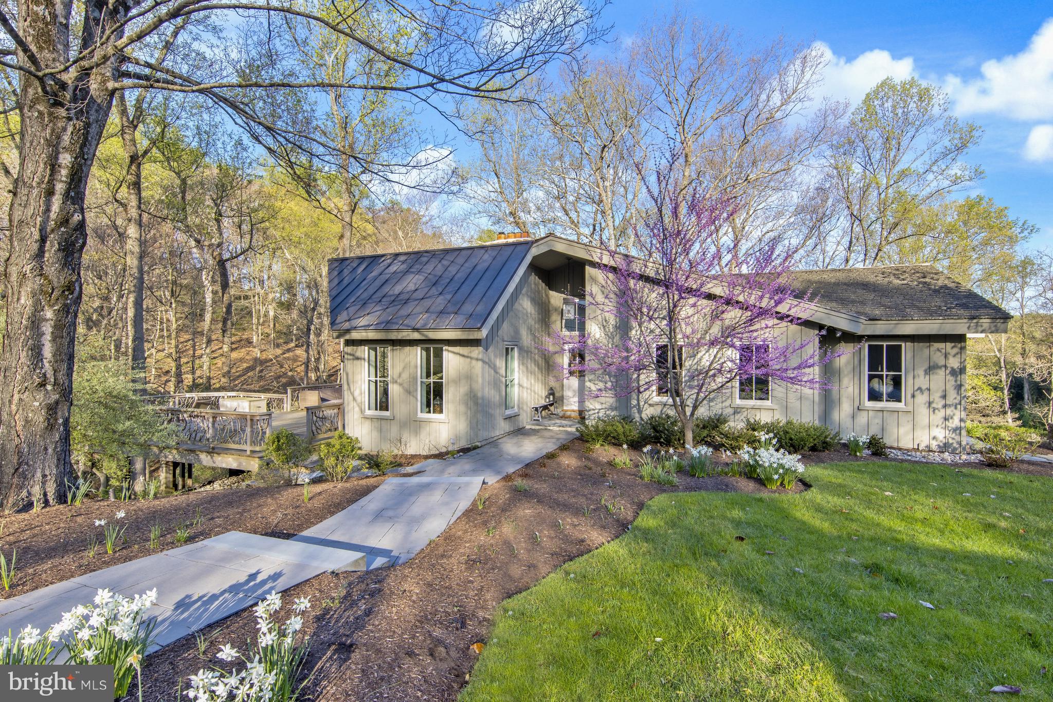 Pass a historic mill on a long scenic lane to 1219 Fairville Rd. This premier property is in the heart of Pennsbury Township and is situated on 18 acres of what was originally part of the Haskell family holdings at the Pennsbury Mill. This property provides stunning views from every window and provides absolute privacy. The main house, built in 1978 and completely renovated in 2013, was thoughtfully constructed so owners could fully indulge in the tranquil natural surroundings. This one-of-a kind home lives large and is appointed with premium finishes and amenities throughout. Through new custom divided-light windows and French doors, the sounds of nature are just steps away. Enter into the dramatic center hall with soaring ceiling and skylights, ending in a quiet conservatory. To the left of the main entrance find the grand living room with vaulted ceiling and stone fireplace. French doors open to the sprawling deck with natural wood and branch railings and overlook a pond and stream that feeds the Mill. To the right of the main entrance is a comfortable family room. Continue through to the mudroom with antique brick flooring and barn wood paneling and onto the state-of-the-art Waterbury Chef’s kitchen. This heart of the home features custom cabinetry, soapstone counters, Wolf 6-burner cooktop, double oven & warming drawer, Subzero fridge, Asko dishwasher and large open dining room. Two luxurious suites sit at the rear of the home. The primary suite offers large walk-in closets/dressing room and Waterbury en suite with Victoria & Albert soaking tub and double vanity, and Italian mosaic tile floor, shower and water closet. A formal office with paneling and fireplace and powder room completes the main level. Downstairs find a second suite, sitting/play room, second office with built-ins and large walk-out game room with wet bar. Through French doors, access the large bluestone patio with fire-pit and walkway to the guest cottage. The secondary guest cottage was renovated in 2008 from the original Amish bank barn. This cottage features a 4th suite, vast great room with vaulted ceiling and kitchenette and is perfect for work-from-home requirements or any number of needs. An oversized 3-bay garage and storage building was constructed in 2014. This home is located in the Unionville-Chadds Ford school district and is just minutes from downtown Wilmington Amtrak Station, Chadds Ford and Philadelphia airport.