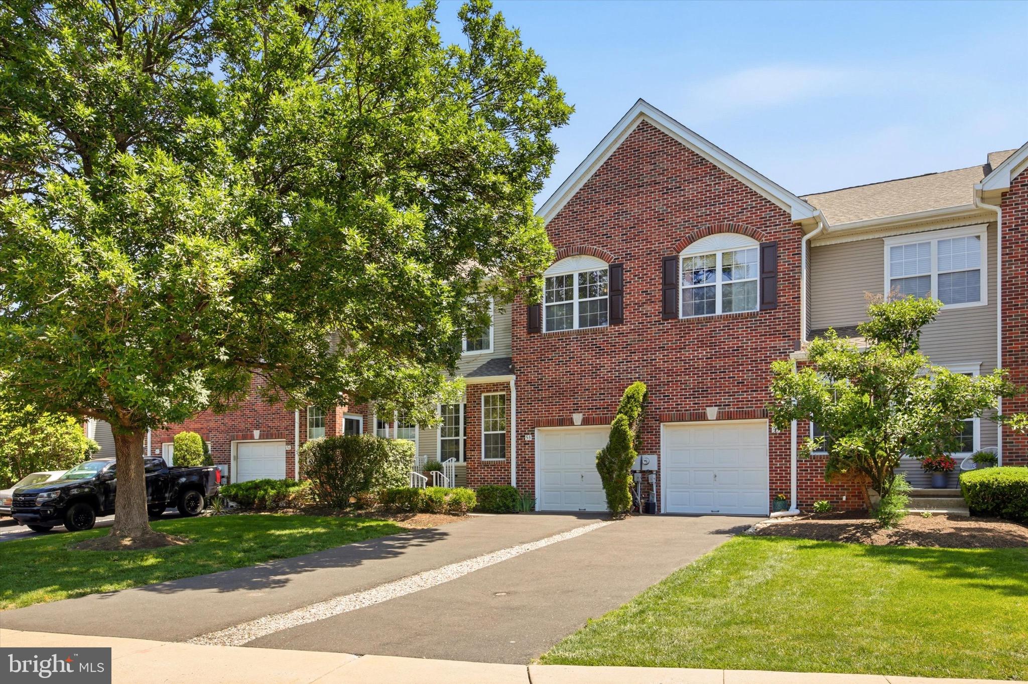 This brick front townhome opens into a bright, open concept main level where the living room, dining area, and kitchen flow together under rich hardwood floors and recessed lighting. Oversized windows line the front of the home and fill the space with natural light all day long.
The kitchen is a standout, finished with granite countertops, full maple cabinetry, and a complete stainless steel appliance package. A raised breakfast bar with decorative corbels offers casual seating and anchors the room, while the layout keeps you connected to the dining and living spaces no matter what you are working on. A slider leads out to the rear deck, perfect for grilling and outdoor dining.
The true showpiece is the two story great room. A soaring vaulted ceiling, a wall of windows, and a classic fireplace give this space genuine drama, while an open staircase and second floor overlook add architectural character you rarely find at this price point.
Upstairs, the primary suite features a vaulted ceiling and a fully renovated bathroom that lives like a spa: a freestanding soaking tub, an oversized glass walk in shower with a tiled niche, and a double vanity topped with marble and finished with modern black fixtures. Two additional bedrooms, both with vaulted ceilings and generous closet space, share a second full bathroom.
The fully finished basement adds valuable living space that adapts to whatever you need, whether that is a home office, gym, media room, or playroom. A one car attached garage with interior access completes the package.
Residents enjoy access to a community pool, tennis courts, and beautifully maintained common grounds. Set in the heart of Washington Crossing, the home is just minutes from the Delaware River, scenic trails, and the shops and restaurants of Newtown and New Hope.
Three bedrooms, two and a half baths, a finished basement, a private deck, and resort style amenities, offered at $715,000 in one of Bucks County's most desirable settings.
