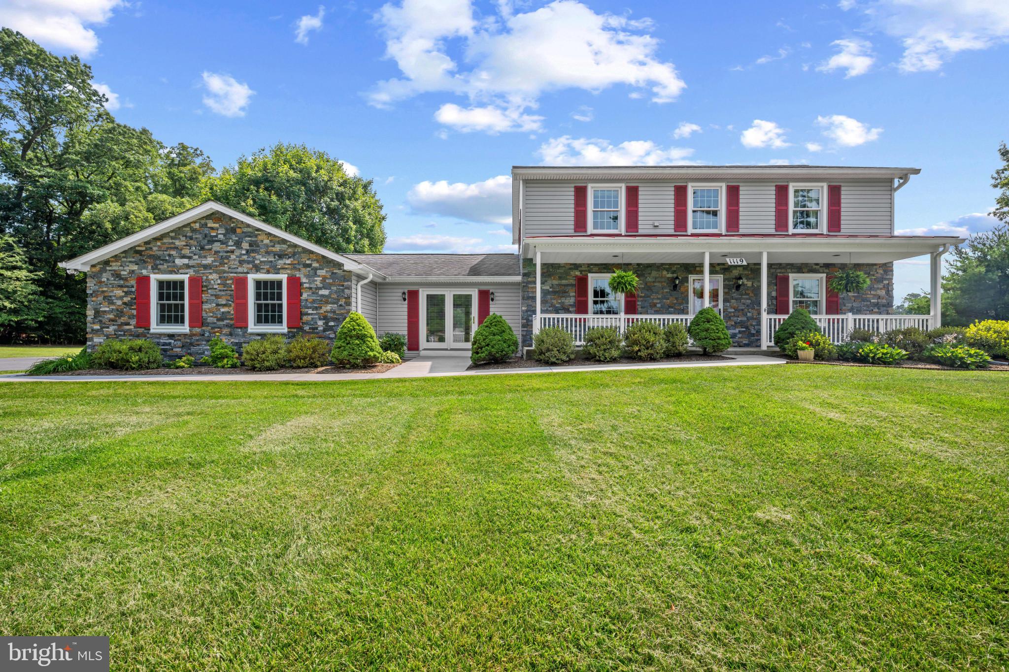 Nestled on over three picturesque acres in the heart of Sykesville, this timeless Colonial showcases classic curb appeal with an inviting façade accented by stone detailing, charming red shutters, and a welcoming front porch. Blending traditional character with exceptional space, the home offers 4 bedrooms, 2 full and 1 half bathrooms, 3,840 square feet, an attached 3-car garage, and an impressive detached garage with room for six additional vehicles, a workshop, hobbies, or abundant storage.

A traditional floor plan welcomes you inside, where inviting living spaces make you feel right at home. Just off the entry, the spacious living room flows effortlessly into the formal dining room, complete with a bay window and elegant chair rail molding. French doors open to the breakfast area and well-appointed kitchen, featuring upgraded countertops, a tile backsplash, and ample space for everyday living or entertaining.

Overlooking the kitchen, the expansive sunroom is the heart of the home. Soaring wood-plank vaulted ceilings with skylights, walls of windows framing picturesque views of the surrounding countryside, and generous space for gathering, or relaxing make this room one you'll never want to leave. Nearby, the bright and airy family room with vaulted ceilings offers yet another comfortable place to unwind. A main-level bedroom and convenient powder room complete the first floor.

Upstairs, you'll find three spacious bedrooms, including the tranquil primary suite featuring plush carpeting and a private ensuite bath with a soaking tub, separate shower, and classic tile finishes. Two additional bedrooms share a bright, well-appointed full bath, while the conveniently located upper-level laundry room adds everyday ease. The unfinished lower level offers endless possibilities to create additional living space or simply provides storage.

Outside, a spacious deck overlooks the expansive backyard, offering plenty of room to relax, entertain, garden, or enjoy the peaceful setting. Beneath the sunroom, an additional attached garage provides the perfect space for a workshop, lawn equipment, or outdoor storage.

Enjoy the best of small-town living just minutes from Historic Downtown Sykesville, where charming boutiques, locally owned cafés, restaurants, and year-round community events create a vibrant atmosphere. Nearby Piney Run Park offers opportunities for hiking, fishing, and boating, while shopping, dining, and major commuter routes are all conveniently close.