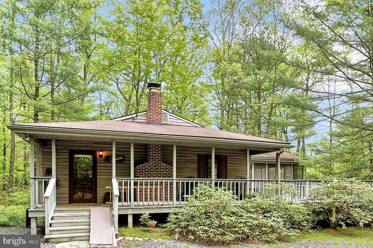 Cozy and serene backdrop for this home surrounded in privacy and walking trails. Featuring a wraparound porch with large deck and screened in porch and an amazing outdoor space, perfect for family gatherings. Open concept floor plan with a large great room with wood fireplace, kitchen and dining area, and two bedrooms and two full baths. Must see this rare find!