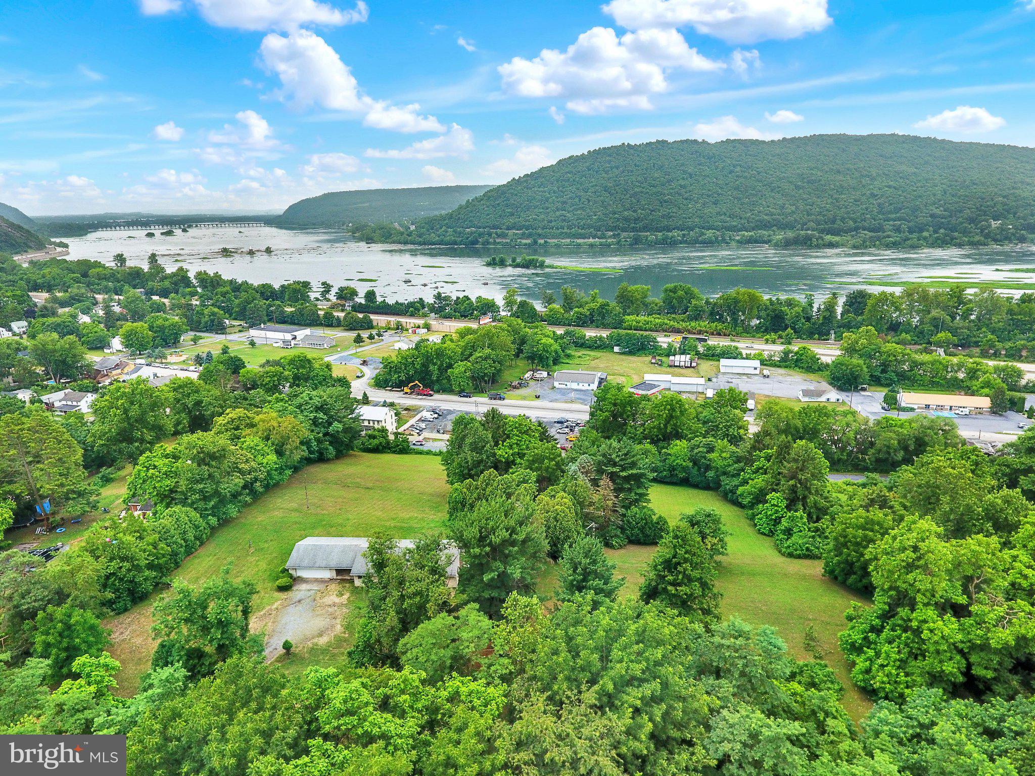 A truly rare opportunity to own one of Dauphin's most remarkable homesites! Nestled atop a combined 3.55 acres across three parcels (1.80, 0.94, and 0.80 acres), this exceptional property showcases breathtaking panoramic views of Blue Mountain, the Susquehanna River, and Harrisburg's iconic Mini Statue of Liberty. Whether you're enjoying your morning coffee or unwinding at sunset, the ever-changing scenery creates an unforgettable backdrop in every season.
The charming full-stone rancher is filled with timeless character and endless potential. Expansive picture windows frame the spectacular vistas, while hardwood floors extend throughout the main level. The formal dining room features classic built-in cabinetry, and the inviting living room is centered around a cozy gas fireplace. A spacious two-car garage is connected to the home by a breezeway—an ideal place to pause and soak in the incredible views that truly set this property apart.
The partially finished lower level provides additional living space and includes a wood-burning fireplace, offering flexibility for a recreation room, family room, or hobby area.
Offering an unparalleled combination of privacy, acreage, and extraordinary scenery, this one-of-a-kind property is conveniently located just minutes from major highways, Harrisburg, and the West Shore. Whether you choose to restore and personalize the existing home or simply enjoy its timeless charm, opportunities like this are few and far between.