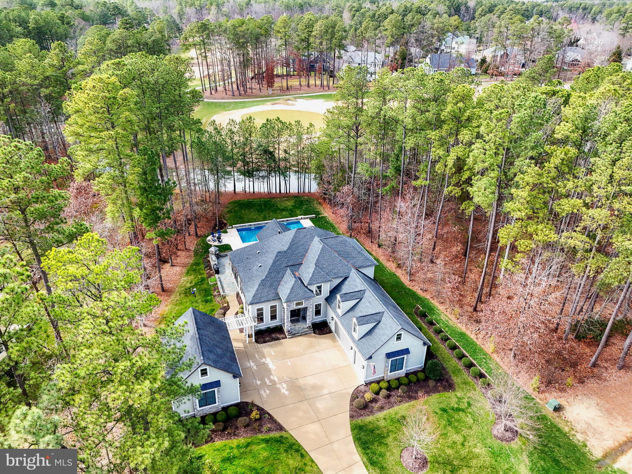 Extraordinary Custom Dream Home with sparkling pool, located inside the gated amenity rich community of Fawn Lake fuses luxury and sophistication with resort style living. Ideally sited overlooking a tranquil pond and the scenic golf course just beyond, this architectural masterpiece with a well appointed interior curated with superior craftsmanship and filled with timeless finishes, effortlessly blends indoor and outdoor living. The stately entrance with an expansive concrete driveway leads to this impressive home with a stunning stacked stone facade and welcoming entryway. The Foyer with soaring ceilings, stunning archways, and solid Oak flooring, creates an elevated style and sets the stage from the moment you step through the door. The elegant Dining Room with exquisite details, rich millwork and expansive Andersen windows provides a perfect backdrop for formal gatherings. A classic Library with a coffered ceiling features a distinctive bookcase with a rolling ladder for easy access to treasured books. The Gourmet Kitchen is the ultimate  chef's dream! Equipped with high-end stainless steel appliances, to include a Wolf 48" Gas Range with 6 Burners, microwave and wall oven, Sub Zero 48" Fridge, ice maker, coffee machine and pot filler. Complete with custom, hand-crafted solid Maple cabinetry, Quartz countertops, tile backsplash and large walk-in pantry! The massive center island is ideal for preparing meals and entertaining. An inviting Breakfast Rmm with soaring ceilings and large windows that provide an abundance of natural sunlight, offers a quaint spot for enjoying meals, and leads to a charming screened Porch with flagstone floors and plenty of space for peaceful outdoor living. The Living Room with vaulted ceilings is anchored by impressive custom-built media cabinets. Featuring a gas Fireplace as the focal point, the space is luxurious, yet casual and inviting. The Sunroom, is a true sanctuary where you can relax and unwind. The main level Owner's Suite is a private escape featuring a luxurious Spa Bath with soaking tub, large tile shower, dual vanities and heated tile floors! A fabulous walk-in closet with an organization system, plus an additional closet offer ample wardrobe storage. The upper level boasts a Bedroom Suite with a private Bath and walk-in closet. Two gracious Bedrooms featuring large walk-in closets share a Full Bath. 
The attention to detail continues in the finished lower level.  Designed with abundant features to entertain and elevate the senses  such as built-in speakers. A large Rec Room is equipped with a full Kitchen and walk-in pantry. Enjoy your favorite movies in the spacious TV Lounge. Work on your fitness in the home Gym, then rejuvenate in the steam Sauna! A versatile space, currently utilized as a Hobby Room, can function as a home theater. 
An incredible sparkling pool is the main attraction of this resort style oasis. The pool includes upgraded features such as a heating and cooling system to create your ideal water temperature, waterfalls, mood lighting, and a retractable cover. The Travertine Marble pool deck offers space for lounging and relaxing poolside! A Flagstone patio, with a built-in stacked stone Wolf BBQ Grill and pizza oven provides an ideal ​area for alfresco dining and entertaining. A scenic pond blends seamlessly with the landscape and is the water source for the lawn irrigation system! 
In addition to the attached 3-Car Garage, this property offers a separate detached oversized 2-Car Garage! Both feature epoxy painted floors and offer abundant space for showcasing your car collection​, or storing your boat and toys! The Mud Rm offers a functional space w/ multiple built-in catch zones, cubbies, a desk with cabinets, and a charging station for phones​! The Laundry Rm with utility sink, features a convenient Pet Shower, plus a water fountain for your furry family members! The home is even equipped with a built-in generator!