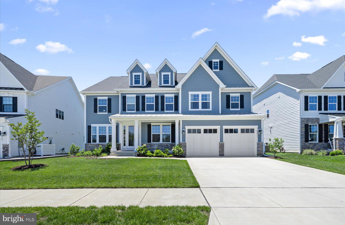 Welcome to coastal luxury at its finest. Built in 2023 and gently enjoyed, this stunning 5-bedroom, 5.5-bath residence offers the perfect blend of sophisticated design, modern comfort, and breathtaking natural surroundings.
A welcoming front porch sets the tone as you arrive, overlooking a beautifully maintained common area. Situated on a premium homesite backing to secluded wetlands, this exceptional property provides a private retreat where Mother Nature serves as your daily backdrop. Whether relaxing on the screened porch, enjoying the outdoor patio with built-in grilling station, or unwinding from the second-level covered porch, you'll appreciate the tranquil sounds of the community's fountained ponds while taking in sweeping wetland views, with Arnell Creek and the Rehoboth Bay visible in the distance.
Inside, beautiful wide-plank flooring extends throughout the main living areas, offering both timeless elegance and easy maintenance. A private executive office provides the ideal work-from-home environment, while the entry-level bedroom creates the perfect guest suite or multigenerational living space.
Designed for both everyday living and entertainment, the elegant dining room is ready to host formal gatherings and holiday celebrations. The sought-after open-concept floor plan seamlessly connects the family room and gourmet kitchen, creating an inviting space for family and friends. Soaring ceilings and dramatic floor-to-ceiling windows frame the natural beauty beyond while filling the home with abundant natural light.
The gourmet kitchen is a chef's dream, featuring ample cabinetry, an oversized island with classic quartz countertops, a tasteful and timeless tiled backsplash, stainless appliances, generous dining space, and a walk-in pantry for exceptional storage.
Upstairs, a spacious secondary living area offers the perfect place to relax and unwind. Four generously sized bedrooms, each complete with spacious, walk-in closets and en-suite baths providing comfort and privacy for family and guests alike. The thoughtfully positioned laundry room adds everyday convenience.
The luxurious primary suite serves as a private sanctuary, complete with dual walk-in closets, a comfortable sitting area, and a private sun porch showcasing peaceful creek and bay views. The spa-inspired en-suite bath features dual vanities, a soaking tub, and a spacious walk-in shower.
Residents enjoy an outstanding amenity package including scenic sidewalks, numerous fountained ponds, resort-style pool, state-of-the-art fitness center with sauna, athletic courts for both pickleball and basketball, and a dog park. The community also features inviting grilling stations, a covered outdoor bar for seasonal gatherings, a cozy firepit for relaxing evenings with neighbors and friends, and a well-appointed clubhouse ideal for community events or private gatherings, complete with billiards and additional social spaces. Best of all, this exceptional community is located less than five miles from downtown Rehoboth Beach, offering easy access to award-winning beaches, restaurants, shopping, and entertainment.  This remarkable home delivers the perfect combination of luxury, privacy, and convenience—offering not just a home, but a true coastal lifestyle.