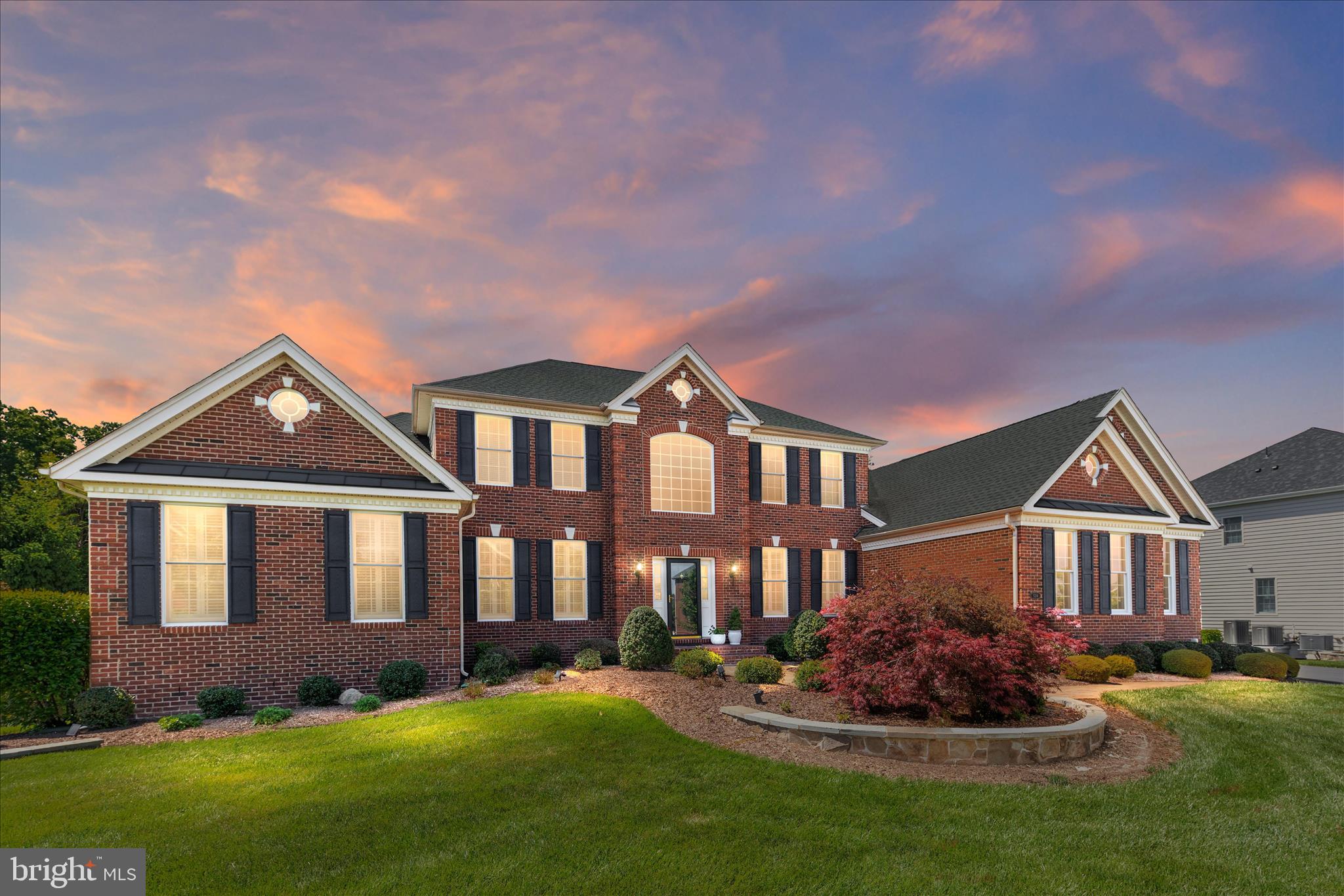**Listed at Appraised Value**
Tucked away on a rare and private .92 acre lot backing to a serene conservation area, this exceptional Cumberland Williamsburg model offers 6,582 finished square feet of refined living in the prestigious gated community of Dominion Valley Country Club. From the moment you arrive, the stately curb appeal, side-load three-car garage, extended driveway, and professionally landscaped grounds set the tone for what awaits inside. A dramatic two-story foyer with gleaming hardwood floors, crown molding, and elegant shadowbox trim welcomes you into the home. Designed for both everyday living and grand entertaining, the open concept layout features a stunning gourmet kitchen complete with updated quartz countertops, subway tile backsplash, upgraded maple cabinetry with glass accents and end panels, gas cooktop, double wall ovens, French door refrigerator, spacious island, pantry, and hardwood flooring. The adjoining two-story family room is the true heart of the home, showcasing a soaring vaulted ceiling, wall of windows overlooking the private backyard, built-ins, gas fireplace, surround sound speakers, plantation shutters, and a secondary rear staircase. Just beyond, the light-filled solarium with vaulted ceiling and tile flooring opens to the expansive Trex deck, creating the perfect indoor-outdoor flow for entertaining or simply enjoying the peaceful wooded views. Set on one of the largest and most private lots in Dominion Valley, the backyard offers endless possibilities to create the outdoor retreat of your dreams. Whether you envision a custom pool, outdoor kitchen, firepit lounge, sports court, or a resort-style backyard oasis, this expansive homesite provides the perfect canvas to bring your vision to life while enjoying the privacy and beauty of the surrounding conservation area. The luxurious main-level primary suite offers a private retreat with hardwood flooring, double-door entry, sitting area framed by decorative columns, dual walk-in closets, and a spa-inspired bath featuring marble countertops, dual vanities, soaking tub, oversized shower with bench seating, vaulted ceiling, and plantation shutters. Upstairs, plush new carpeting extends throughout the spacious secondary bedrooms, including a private princess suite with en suite bath and walk-in closet, two additional bedrooms connected by a Jack-and-Jill bath, a spacious loft area with recessed lighting and crown molding, and a finished upper-level storage room with hardwood flooring. The finished walk-out lower level offers incredible versatility with 9-foot ceilings, abundant daylight windows, a sprawling recreation room with rough-in for a future wet bar, a den, full bath, workshop, and oversized storage area. Outside, the backyard continues with an expansive paver patio, fountain, deck speakers, irrigation system, and mature landscaping designed for year-round enjoyment and privacy. Additional upgrades include Hunter Douglas plantation shutters and silhouette shades, custom window treatments, new Zone 1 HVAC system installed in 2025, and new garage door openers. Living in Dominion Valley Country Club means enjoying an unmatched lifestyle with access to an Arnold Palmer Signature golf course, renovated clubhouse, state-of-the-art fitness center, indoor and outdoor pools, tennis and pickleball courts, scenic walking trails, and highly rated schools located within the community. Conveniently located near shopping, dining, wineries, breweries, and major commuter routes. Rare opportunities like this do not come along often. Schedule your private tour today and experience the lifestyle that makes Dominion Valley Country Club one of Northern Virginia’s most sought-after communities.