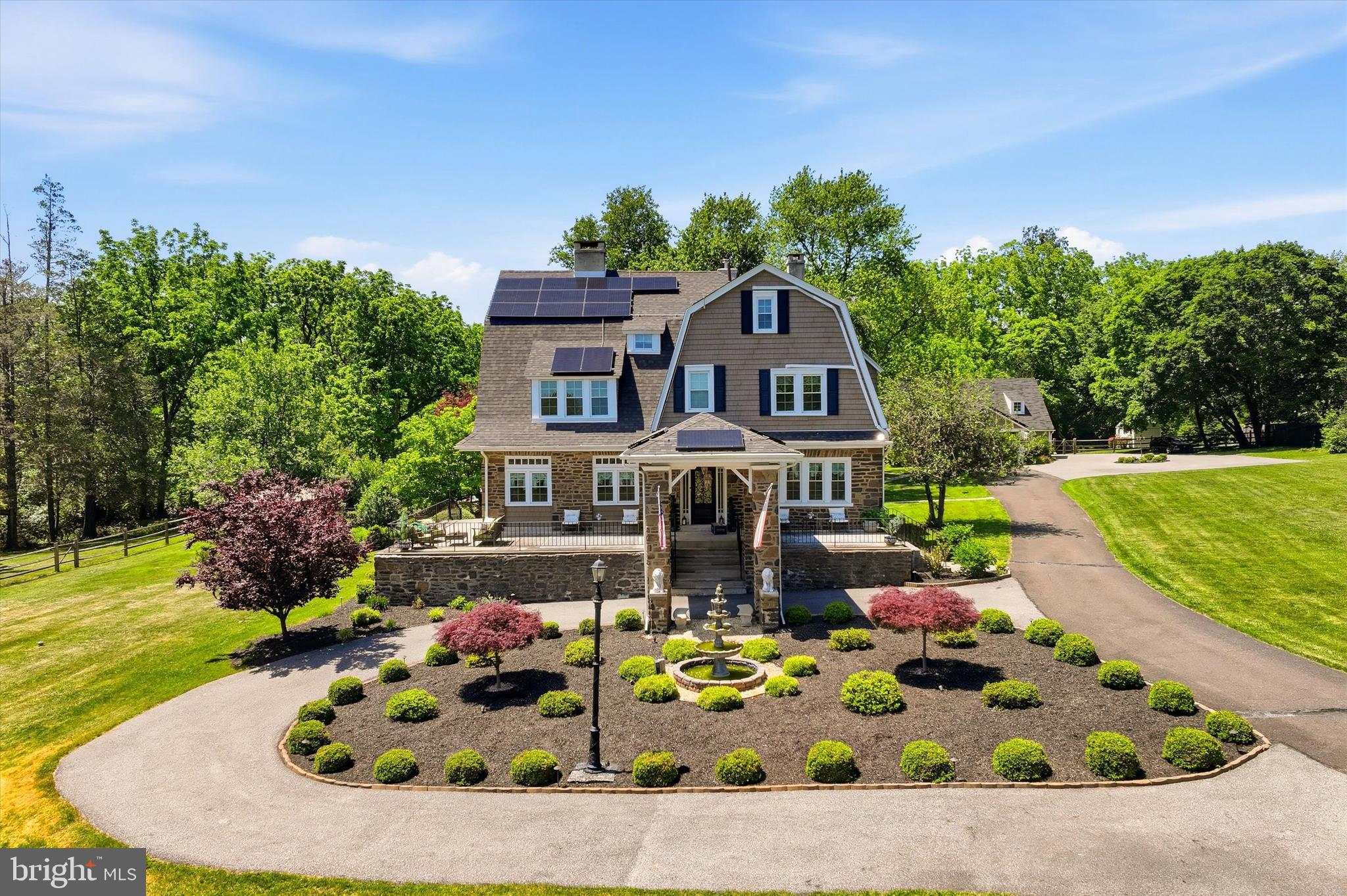 Welcome to 917 DeKalb Pike - a rare, fully upgraded stone estate offering exceptional space, privacy, and versatility on over 3.5 acres in prestigious Lower Gwynedd Township and the highly-rated Wissahickon School District.

Set well back from the road and accessed by a private gated drive, this fully fenced-in property delivers a true estate setting with the convenience of nearby major routes, regional rail, premium grocers like Whole Foods, and the vibrant dining and shopping scene of Ambler. The main residence, a classic early-20th-century stone Colonial, blends timeless architectural character with thoughtful expansions and more than $500,000 in modern upgrades.

The restored interiors showcase original hardwood floors, detailed millwork, and gracious entertaining spaces, including a sweeping formal living room with four fireplaces, expansive windows, and elegant flow between rooms. The home offers over 6,100 total square feet of living space (4,941 above grade plus a finished basement) with seven bedrooms and multiple flexible-use areas ideal for today's needs, whether for remote work, creative studios, or multi-generational living.

At the heart of the home, the expanded chef's kitchen features custom soft-close cabinetry, a massive center island, granite countertops, a farmhouse sink, high-end smart appliances, and a walk-in pantry with custom shelving, seamlessly connecting to both indoor and outdoor living areas. Multiple renovated bathrooms, including a spacious primary suite featuring a double vanity, bidet, and expansive double shower with a bench, provide modern comfort while preserving the home's character.

Beyond the main house, the estate truly distinguishes itself. A detached studio-style guest cottage with a full kitchen and bath is perfect for use as a pool house, an Airbnb, au pair housing, or more! What's more, a substantial 3-car detached garage offers owners and guests plenty of undercover parking along with an 8-vehicle parking lot, as well as room for storage, and the large second floor above is ready to be finished. The expansive grounds open the door to a wide range of possibilities, whether for extended family, guest accommodations, a home business, or future customization. The outdoor environment is designed for both relaxation and elite entertaining, featuring a fully upgraded saltwater pool with tanning ledge, waterfall, and slide, along with a brand-new hot tub and gazebo, outdoor kitchen,built-in fire pit, and recreation areas including bocce and horseshoe courts. The setting offers a private, resort-like experience rarely found in this location.

Extensive recent improvements provide peace of mind and long-term efficiency (and massive utility savings), including a new 50-year roof, 54 brand-new windows, air conditioning, updated electrical with complete removal of knob-and-tube wiring and a whole-home surge protector, new cedar impression siding and gutters, and a whole-home water filtration system. A 72-panel solar array was installed in 2022 and delivers a peak output of 25.92 kWp (significantly lowering your electric bill), complemented by underground electrical service for enhanced reliability in our changing times. In 2025, the home was further upgraded with a new high-capacity natural gas heating system, replacing the original oil furnace system. Other updates and repairs, including chimney restoration and interior refinishing, reflect the consistent care and investment the owners have lovingly put into their home.

With its combination of historic charm, modern infrastructure, expansive grounds, and multiple auxiliary structures, 917 DeKalb Pike offers a unique opportunity to enjoy a turnkey estate immediately while still providing the flexibility to tailor the property to your vision over time.
