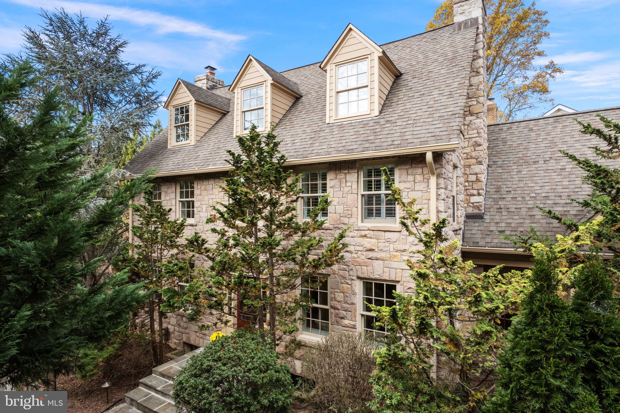 Historic charm meets modern living in N Arlington! Step into the perfect blend of timeless elegance and contemporary comfort in this 1925 European-inspired, completely renovated center hall Colonial in N Arlington's Bluemont neighborhood-conveniently located close to Ballston and Westover shops, parks & trails. This move-in ready home with 5 BRs (or 4 BR + Den) and 3.5 BAs is ideal for the buyer who appreciates the unique character of historic architecture with the convenience of modern updates. With its retreat-like feel, this hidden gem is nestled in the Brockwood section of Bluemont; within 10” thick, hand-cut granite exterior and interior walls. Thoughtfully preserved period details include high ceilings, newly refinished original white oak floors, thick crown and baseboard molding, chair rails, deep sill windows, wooden interior plantation shutters, and 2 original stone wood-burning fireplaces that evoke the home’s historical 1920s roots and exceptional craftsmanship. This one-of-a-kind home also offers plenty of exterior living, dining, and entertaining space, including the inviting screened-in porch with stone and stucco walls, which leads to the fully fenced, lush, landscaped meandering cobblestone path gardens professionally illuminated at night. 
The large and open gourmet kitchen includes tons of granite counter space for cooking and top-of-the-line Wolf, Sub-Zero, Viking, and Bosch stainless steel appliances, to-the-ceiling cherry cabinetry, and double pantry space—ideal for cooking, entertaining, and flowing seamlessly into the large family room and dining space. Climb the wide center hall stairs to the second floor, which offers 3 BRs (or 2 + Study/Den), a generous laundry room, and an owner’s suite, including a private retreat with a spacious walk-in closet bathed in natural light. Delight in the luxurious en suite bath Kohler SOK Effervescence tub and separate stall shower with Italian travertine stone and new Grohe shower system. The third floor with brand new plush carpet offers two large bedrooms with charming deep dormer arched windows, a full bath, and a shared lounge and bar space eliciting a private, cozy loft vibe with breathtaking, light-filled, tree-top views. The wine enthusiast will love the lower-level custom-built wine cellar with space for approximately 750 bottles. 
There are many system upgrades such as a new gas instantaneous hot water heater, 300+ amp electrical, and HVAC, (2020). Centrally located, this home is walking and biking distance to Custis and W&OD Trails, Bon Air Park Garden with tennis courts, rose garden, and playing fields, Bluemont Park, grocery stores, Ballston Metro, Rt 66, and Rt. 50.