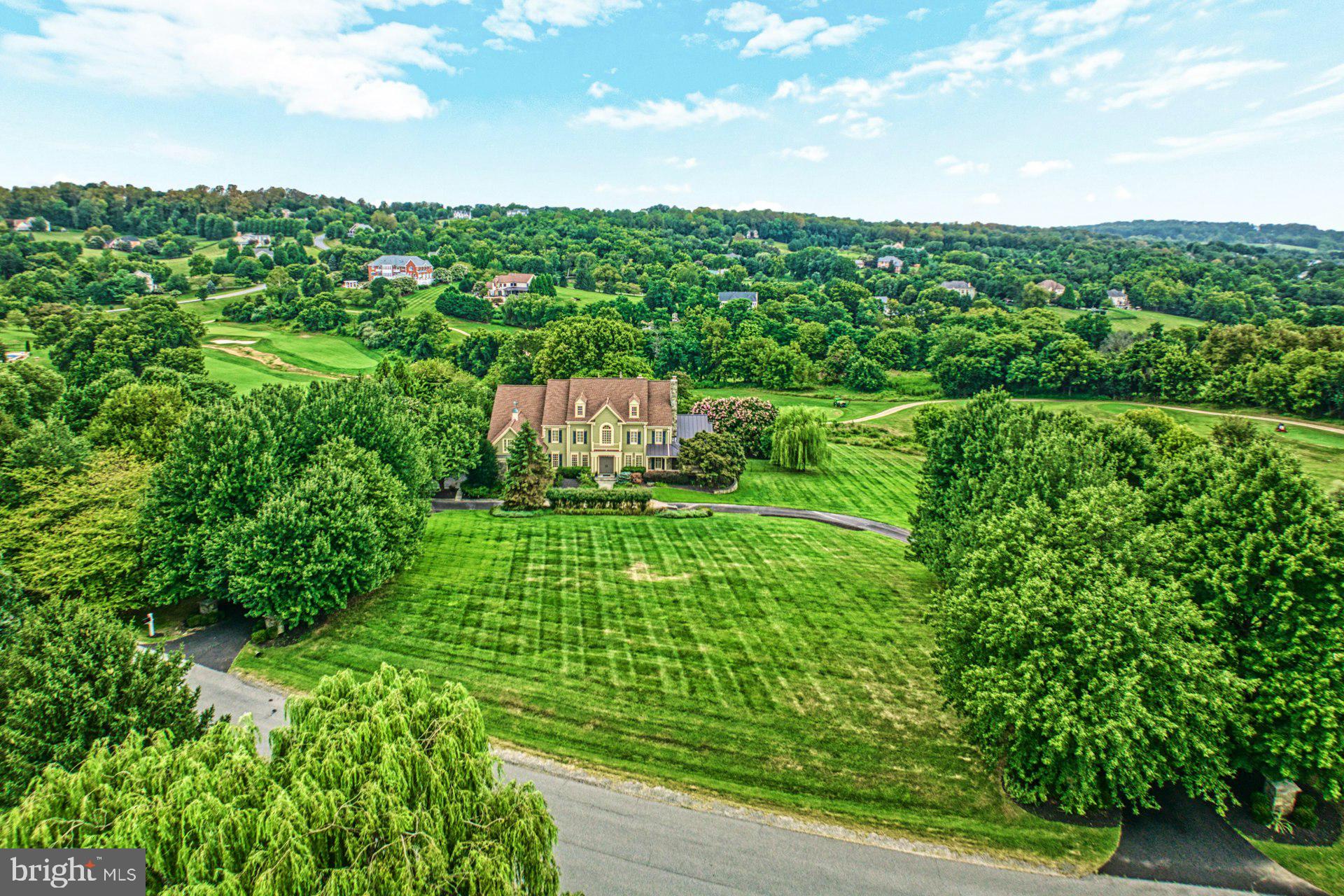 Nestled on over 4 private acres in one of Loudoun’s most prestigious estate communities, this exquisitely updated Grand Monet residence—once a former Renaissance model home—offers refined living at its finest. Perfectly positioned on a premier lot backing to open space, the home captures sweeping views and showcases nearly $500,000 in luxurious updates.

A grand circular driveway welcomes you to this stately manor, where manicured landscaping sets the tone for the elegance found within. Inside, the main level unfolds with a dramatic two-story foyer, formal living and dining rooms adorned with detailed millwork, a sun-drenched conservatory, and a richly appointed home office with custom built-ins. Designed for both everyday ease and grand-scale entertaining, the home features integrated surround sound and effortless flow between its gathering spaces.

At the heart of the home, a newly reimagined white chef’s kitchen stuns with top-of-the-line appliances, an oversized center island, designer lighting, and bespoke cabinetry—ideal for the culinary enthusiast. The adjacent sunroom and family room offer panoramic views of the sprawling backyard oasis.

Upstairs, the expansive primary suite is a true retreat, featuring multiple walk-in closets and a spa-like bath with soaking tub, dual vanities, and a generous walk-in shower. Additional guest en-suites provide comfort and privacy for loved ones or visitors.

Step outside to experience resort-inspired living: a sparkling pool surrounded by flagstone patios and lush lawn invites outdoor entertaining against a backdrop of rolling hills. Enjoy peace of mind with a new roof, four recently updated HVAC systems, and thoughtfully designed landscaping throughout.

With the timeless elegance of a former model home and the sophistication of today’s most desired upgrades, this extraordinary property offers the perfect balance of classic beauty and modern luxury.