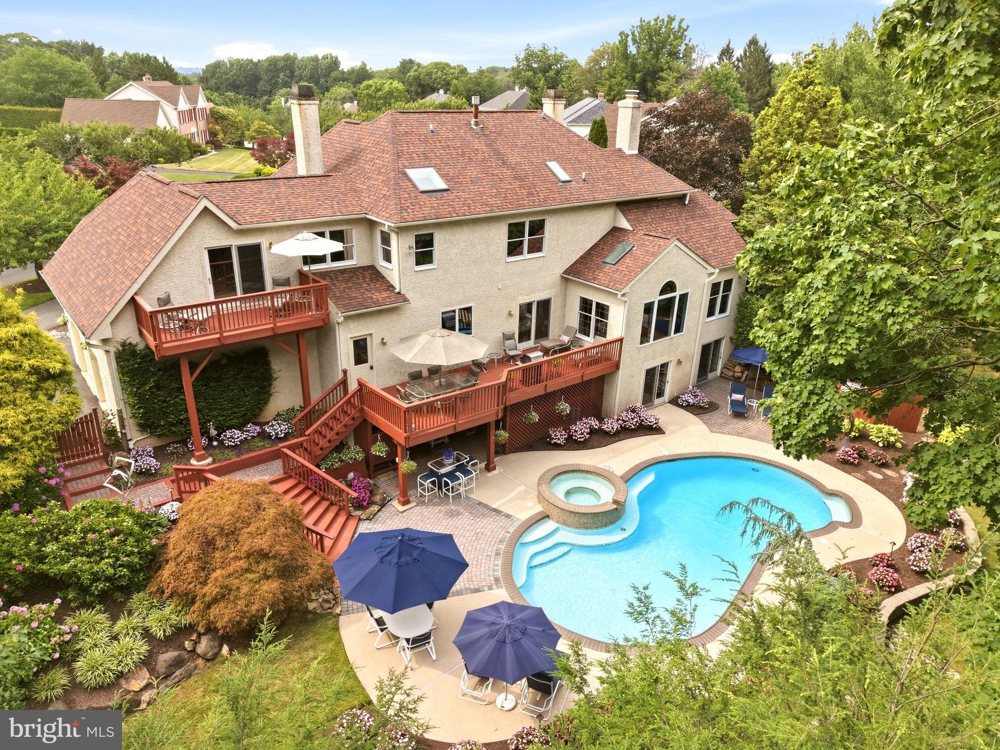 An extraordinary custom estate tucked away on a quiet cul-de-sac in the prestigious **Thornbury Hunt** community. Located within the award-winning **West Chester Area School District** and offering the advantage of low taxes, this remarkable residence seamlessly blends timeless craftsmanship, thoughtful design, and resort-inspired living.

From the moment you arrive, the meticulously landscaped grounds create an unforgettable first impression. Mature trees, lush gardens, and spectacular blooming hydrangeas surround the property, creating a private backyard oasis that feels like your own botanical retreat.

Offering **4 bedrooms, 5 full bathrooms, and 1 powder room**, this exceptional home was thoughtfully designed for both elegant entertaining and comfortable everyday living. Rich architectural details, custom millwork, and **three fireplaces** create warmth throughout, including a dramatic **three-sided fireplace** in the luxurious primary suite, a **double-sided fireplace** shared between the family room and the spectacular office addition, and a classic fireplace in the formal living room.

The heart of the home is the expansive kitchen, which flows seamlessly into the family room and opens to a spacious deck overlooking the resort-style backyard. Just off the kitchen is a dedicated office, perfectly positioned for managing daily life while remaining connected to the home's main living spaces.

A standout feature of the home is the impressive **office addition**, complete with soaring vaulted ceilings and a stunning double-sided fireplace shared with the family room. Filled with natural light, this beautiful space creates an inspiring work-from-home environment while showcasing the home's exceptional craftsmanship and architectural character.

The primary suite is truly in a class of its own. Designed as a private retreat, it features **separate his-and-her bathrooms and custom-designed walk-in closets**, providing an unmatched level of luxury and privacy. Her spa-inspired bath includes a Jacuzzi soaking tub, separate walk-in shower, and custom built-in cabinetry, while a private deck overlooks the breathtaking backyard. Even everyday convenience was thoughtfully considered with a **laundry chute directly from the primary suite**.

The finished walkout lower level offers an incredible extension of the home's living space. At its center is a **private indoor plunge spa featuring 14 therapeutic jets**, providing year-round relaxation, wellness, and low-impact exercise. The expansive lower level offers endless possibilities for entertaining, recreation, fitness, or extended guest accommodations.

Outside, every detail has been designed to create a private resort experience. The expansive deck off the kitchen leads down to the heated in-ground pool and spa, surrounded by lush landscaping and spectacular seasonal hydrangea gardens. A custom **teak outdoor shower** completes this extraordinary outdoor retreat, offering the perfect finishing touch after a day spent enjoying the pool.

Additional highlights include an **elevator providing convenient access between levels**, a spacious **three-car garage**, abundant storage with a walk-in attic, updated mechanical systems and appliances, and exceptional craftsmanship throughout.

Perfectly positioned in one of Thornton's most desirable neighborhoods, Thornbury Hunt offers the tranquility of a cul-de-sac setting while remaining just minutes from West Chester Borough, Route 202, shopping, dining, and parks.

13 Chesterland Drive is more than a home...it's a private retreat where luxury, comfort, and timeless design come together to create an exceptional lifestyle.