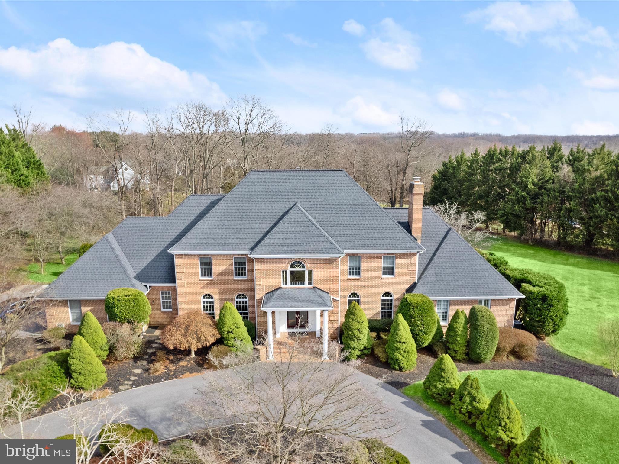 Elegant five bedroom, four full bath, two half bath, Brick Estate located in the coveted "The Chase" subdivision in Ellicott City, zoned to River Hill High School, Folly Quarter Middle School and Triadelphia Ridge Elementary School. Sited on a beautifully manicured, very private, 2.84 acre lot, framed by trees and dense woods. Recently installed asphalt circular and side  driveway and Custom 92" stained and beveled double glass entry doors welcome you to the brick front entrance stairs. Impressionable marble towering  two story entrance foyer with dramatic circular staircase ushers you into this spectacular residence. First AND second floor spacious primary owner suite's BOTH with recently updated luxurious spa like baths, jacuzzi tubs, large stall showers and sauna. Sun drenched two story family room with marble fireplace with wood stove insert. Large Gourmet chef's kitchen with access to colossal size covered porch overlooking almost 90 yards of flat lush green lawns, landscaped beds and dense woods. Formal living room with marble wood burning fireplace. Home Office/Library with built in cherry cabinet shelving. Huge separate dining room for large holiday family gatherings, Hardwood floors, all fresh paint. Three spacious additional bedrooms upstairs with 2 full baths and another unfinished optional room for an additional full bath, if needed. Walk out lower level with grand recreational room, half bath, home theatre area, kitchenette, au pair/ in law suite with walk in closet and attached full bath, make this home very functional to accommodate multi-generational living. Flagstone rear patio accessible by 2 sets of sliders in both the theatre area and grand recreation rooms. Three car side loading garage and expansive asphalt driveways can accommodate 12-14 vehicles. There are 3 security cameras centrally monitored by Vivent Security Systems( Front Door, above the 3 car side loading left side garage and in the rear porch area.