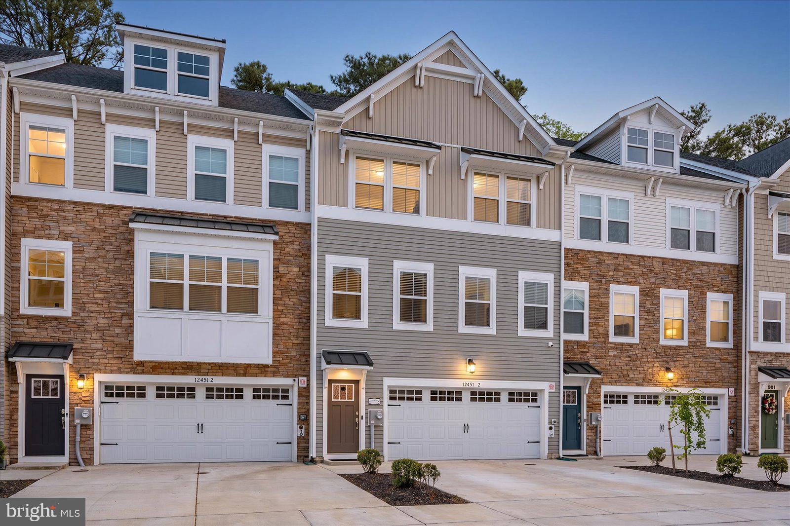 Welcome to Sea Oaks Village — a beautifully designed 2023-built coastal townhome backing directly to a serene wooded buffer for added privacy and tree-lined views. Offering four levels of light-filled living just minutes from the beach, the bay, and everything the Eastern Shore has to offer, this 4-bedroom, 3.5-bath home blends modern construction with a layout built for both quiet mornings and lively gatherings.
Enter through the welcoming front foyer and arrive at a convenient mid-level landing where you can head up to the main living level or down to the ground-floor flex room. That first-floor space features a full bath and a private walkout to the hardscaped rear patio that opens to the tree line — perfect as a home office, media room, gym, guest suite, or fourth-bedroom alternative. The ground level also includes a dedicated laundry/mudroom with direct access from the oversized garage, making everyday in-and-out a breeze.
The main living level is the heart of the home, showcasing an open-concept great room, dining area, a perfectly situated 1/2 bath with hi-end vanity, and a true chef's kitchen with a large walk-in pantry and featuring the upgraded package: double wall ovens, stainless appliances, an oversized quartz island with seating for the whole crew, designer cabinetry, and a sun-drenched morning room that opens to an expansive open-air deck — ideal for grilling, sunset dinners, and unwinding around the fire pit while overlooking the woods. 
The third level features three generously sized bedrooms, including a serene primary suite with a large walk-in closet and a spa-style en-suite bath (oversized tiled shower, dual vanity, and walk-in closet) plus two additional bedrooms served by a full hall bath. Head up to the fourth-floor loft retreat — a versatile bonus suite with its own private walkout balcony perched at treetop level — easily used as a fourth bedroom, second primary, teen suite, or rec room.
Built in 2023 with all the modern systems, energy-efficient features, and warranty-era peace of mind that come with newer construction, this home lives larger than the square footage suggests, with the wooded rear setting delivering a true sense of escape. Sea Oaks Village offers resort-style amenities including an outdoor pool and clubhouse, sport court, playground, fishing pier, and tranquil ponds and walking paths winding through the neighborhood. A short drive lands you at the white-sand beaches and boardwalk of Ocean City, the wild ponies and protected dunes of Assateague Island National Seashore, and the charming shops, galleries, and award-winning dining of historic downtown Berlin — repeatedly named one of America's Coolest Small Towns. Local favorites like Sunset Grille, Hooper's, On The Bay Bistro, Fager's Island, and the Shark on the Harbor are just minutes away, along with Tanger Outlets, Eagle's Landing Golf Course, and the West OC marinas.