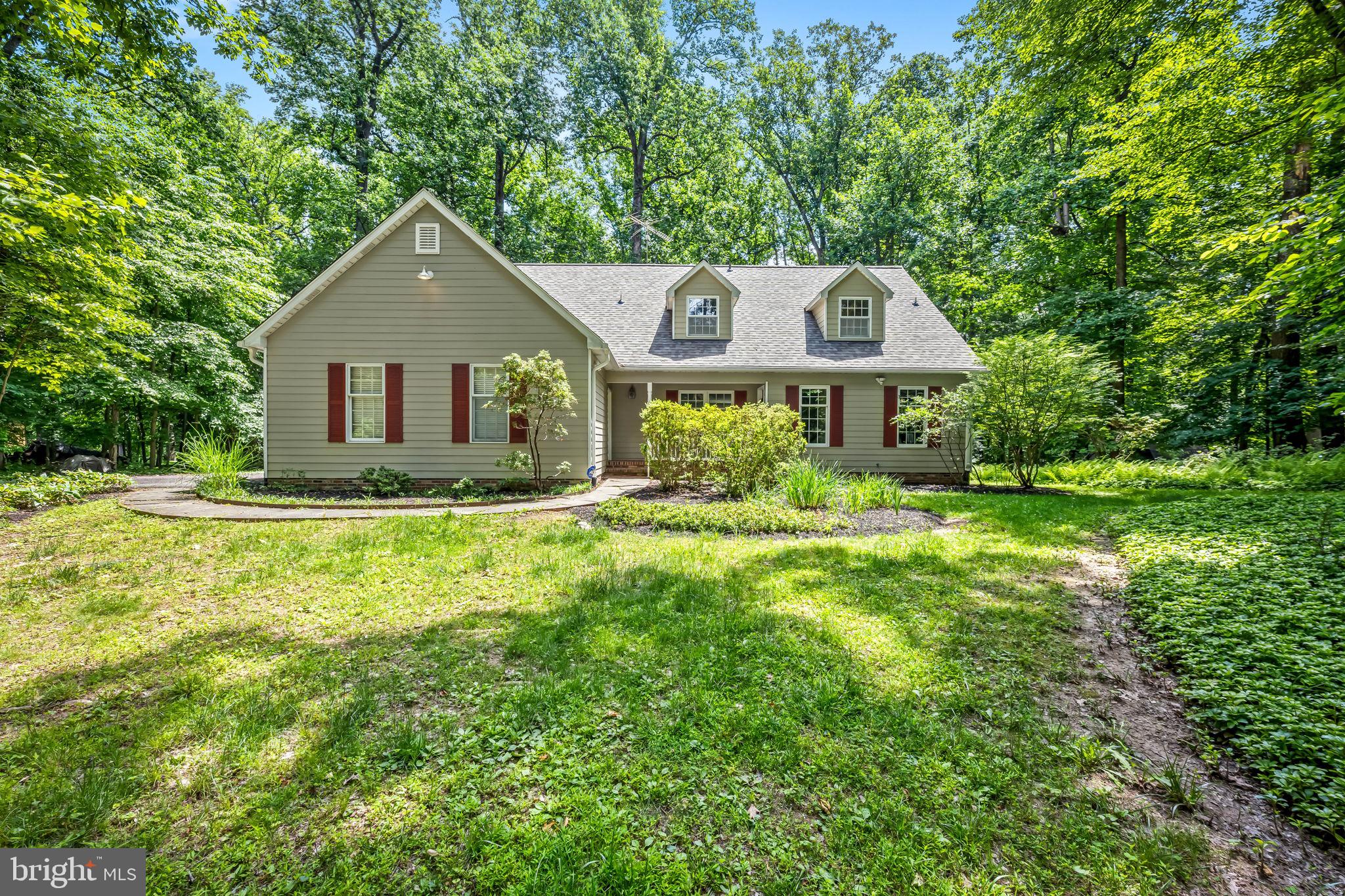 Welcome to 7 Pemberly Lane, a private retreat nestled on 1.7 picturesque acres in Sagamore Forest. Surrounded by mature trees and natural beauty, this charming home offers the perfect blend of comfort, character, and opportunity. The open-concept main level features beautiful hardwood flooring throughout. The eat-in kitchen offers  warm wood cabinetry, granite countertops, a breakfast bar, stainless steel appliances, including a natural gas range, and a adjoining breakfast nook providing the perfect spot for casual meals and morning coffee. The large living room is filled with natural light and centered around a cozy wood-burning fireplace, while an additional area offers flexible space for a home office, reading area, or study. The formal dining room is ideal for entertaining. The spacious main-level primary suite is a true retreat, featuring a second wood-burning fireplace, ample room for a sitting area, a walk-in closet, and a private full bath. Upstairs, hardwood flooring continues throughout two generously sized bedrooms. One bedroom provides access to an incredible attic space with soaring ceilings and abundant natural light—an inspiring opportunity for an artist's studio, creative workspace, or future finished living area. The unfinished lower level offers extensive storage and endless potential for future expansion, whether you envision a recreation room, home gym, or a workshop. A spacious deck overlooks the wooded backyard, creating a peaceful setting for relaxing, entertaining, or simply enjoying the privacy of the property. Major recent updates provide peace of mind, including a brand-new architectural shingle roof in 2026 and a new heating and air conditioning system in 2025.