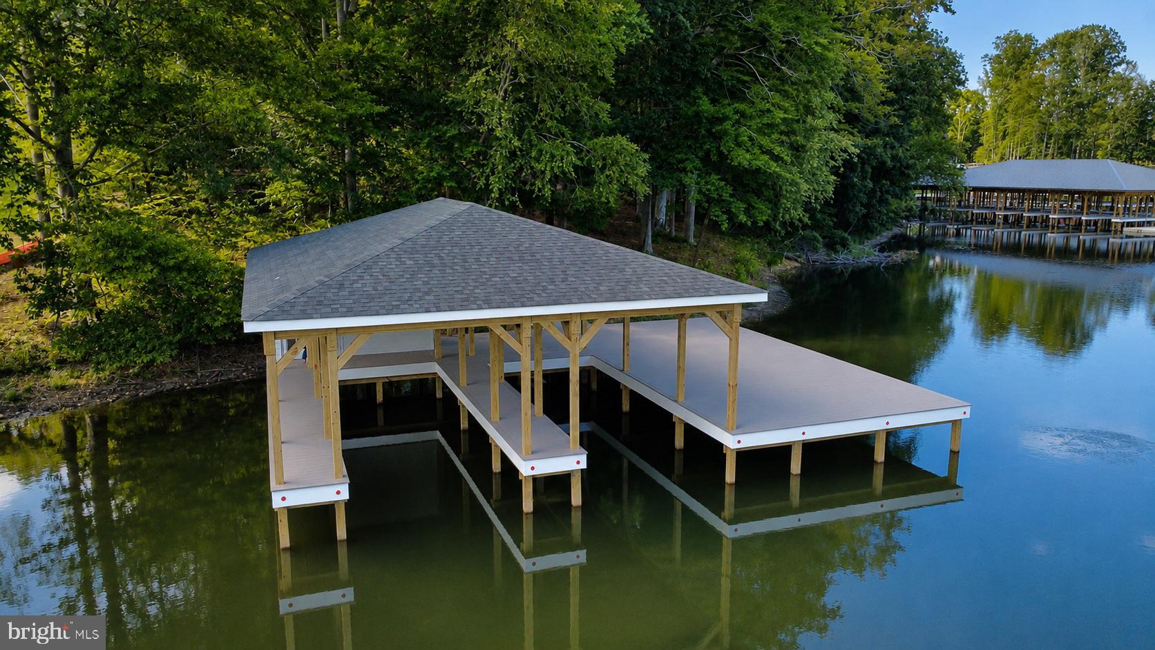 Skip the wait and start living the Lake Anna lifestyle! This Premium vacant lot features a brand new BOATHOUSE with 2 slips, a large storage closet, a covered area to dine or lounge in the shade, a large sunning area, AND deep water.  Enjoy immediate waterfront access with no Dominion or county approval delays and zero boat storage costs, giving you the freedom to build your dream home on your own schedule or hold the property as a lucrative investment.  Driveway entrance has been VDOT approved and installed. Soil work has been completed and can accommodate a conventional drain field. Located in Compass Cove on the private side of Lake Anna.