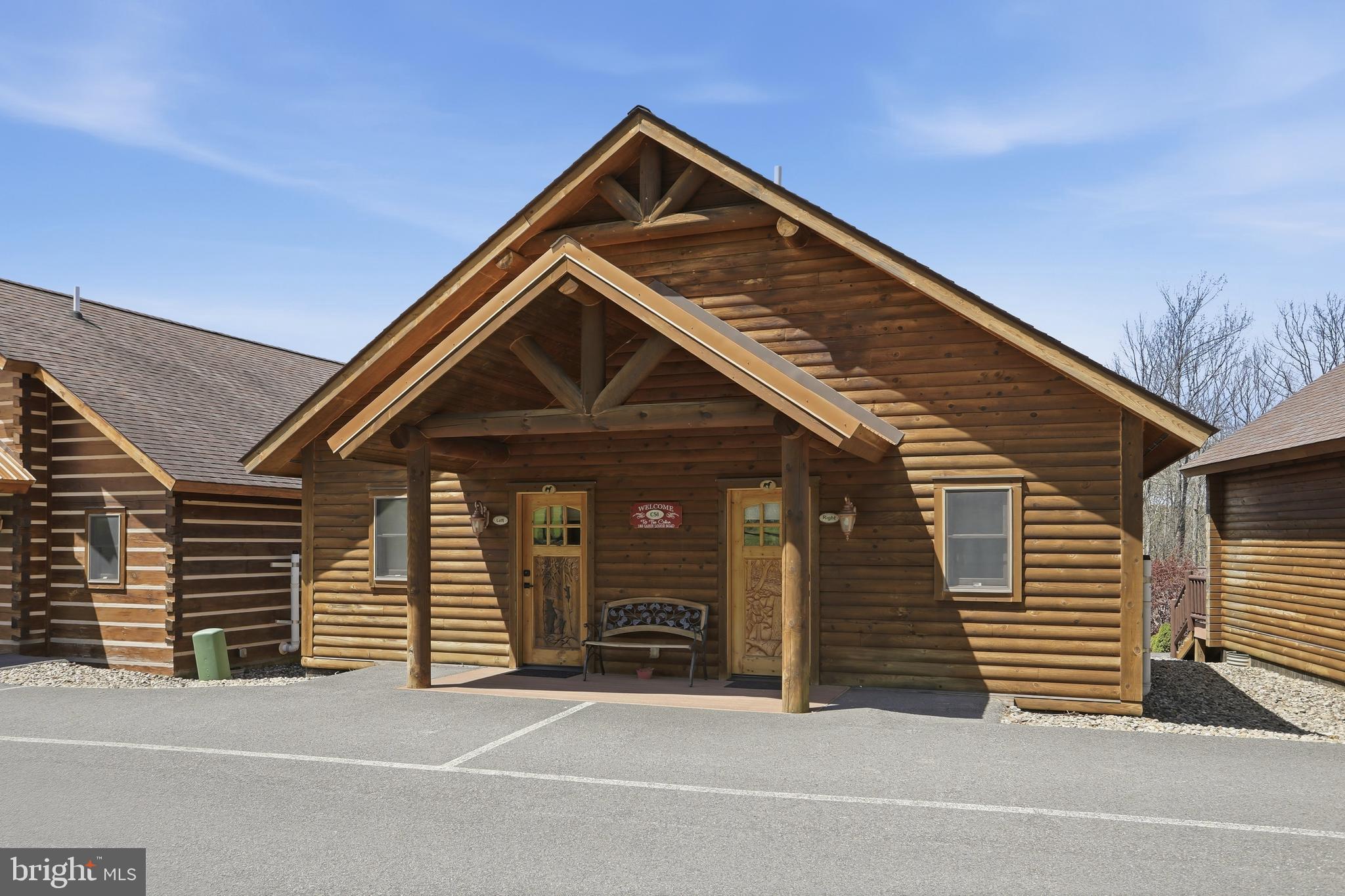 BOAT SLIPS! LAKE ACCESS & VIEWS! 4TH OF JULY FIREWORKS VIEWS! SKI SLOPE VIEWS!  Cabin #51 at The Lodges of Sunset Village is a detached home offering two "lock off" units with a shared door between the units, with 1024 square feet. Each side offers an efficiency-style layout on the main floor with a kitchenette, living room with a sleeper sofa, and a full bath. Each side has two queens and a sleeper sofa in each unit. This cabin also has a deck and patio.

Rich in mountain character and charm, this log cabin features uniquely carved wood doors, beautiful beamed ceilings, warm wood walls, and inviting spaces that create an authentic lake and mountain retreat feel. Additional features include lake views, ski slope views, expansive decks and patios, upgraded finishes, open concept living, stacked stone gas fireplace, and open concept living.

Enjoy incredible views of Deep Creek Lake and Wisp, along with front row seats for seasonal beauty and memorable moments, including views of the annual July 4th fireworks. This property has a proven rental history, generating an average of $66,594  in annual gross rental income, creating an exciting opportunity for buyers seeking both personal enjoyment and investment potential.

Experience one of Deep Creek Lake’s newest ownership opportunities at The Lodges at Sunset Village. For the first time ever, fully furnished lake area cabins are being offered for individual ownership in a breathtaking community featuring incredible lake and Wisp ski slope views. Community amenities include lake access with 10 shared dock slips and an impressive 1,320 square foot waterfront dock area perfect for fishing, swimming, launching kayaks, relaxing by the water, and enjoying summer fun at the lake. Residents and guests also enjoy a lakeside gazebo, playground, fire pit, gathering areas, pet-friendly accommodations, abundant parking, and on-site professional management.

The monthly condo fee provides exceptional convenience, including most utilities, snow removal, trash service, and yard maintenance, for a low-maintenance ownership experience. Whether you're searching for a vacation retreat, income-producing investment, or both, The Lodges at Sunset Village offers a rare opportunity to own at Deep Creek Lake. Owner financing options may be available. 

Stop by our on-site Sales Center at The Lodges Gatehouse (23900 Garrett Highway) during open hours to learn more, explore ownership opportunities, and get your questions answered: Thursdays 2:00–6:00 PM, Fridays 1:00–5:00 PM, Saturdays 10:00 AM–5:00 PM, and Sundays 10:00 AM–2:00 PM or call today for details and your private showing!