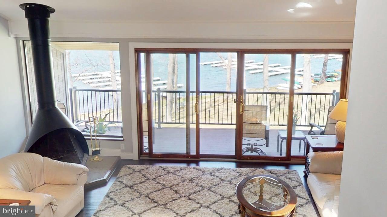 Pack your bags and escape to your move in ready condo located at Four Hooppole South, nestled in peaceful mountain Maryland in one of the most coveted coves of Four-Season Deep Creek Lake.    Enjoy breathtaking views from the deck of your stunning, lakefront, 3+ bedroom, 2 bath condo or cozy up to the free-standing wood fireplace in your spacious livingroom.    Condo boasts many upgrades including:  Carrier mini splits (installed in 2021 and warranted until 10/2031) that supply AC and heat throughout the condo and can be remotely controlled so your condo is at the perfect temperature upon your arrival; all upgraded Pella windows and doors; black stainless appliances and quartz countertops in kitchen; bathrooms updated with ceramic tile and granite countertops;  wood flooring throughout most of the condo.  The enclosed patio entry area includes two outdoor storage closets.   The lakeside offers not only one but two outdoors areas for eating, relaxing or watching the sunrise and set.   Upper deck updated with composite deck boards.  Large lower patio  with extended composite area,   Amenities include private boat slip (located only steps from your condo), boat ramp, sandy beach with swim dock, sports court, lake side volleyball court, community log cabin, and children's play area,   Four Hooppole South consists of 10 acres of pristine grounds with year-round  maintenance staff for worry-free ownership,  Also included is Cable TV, property-wide WiFi, trash removal and paved parking.  All of this and only minutes from restaurants, grocery, skiing, snow tubing, hiking, and many other activities.      Make your appointment for a tour today!