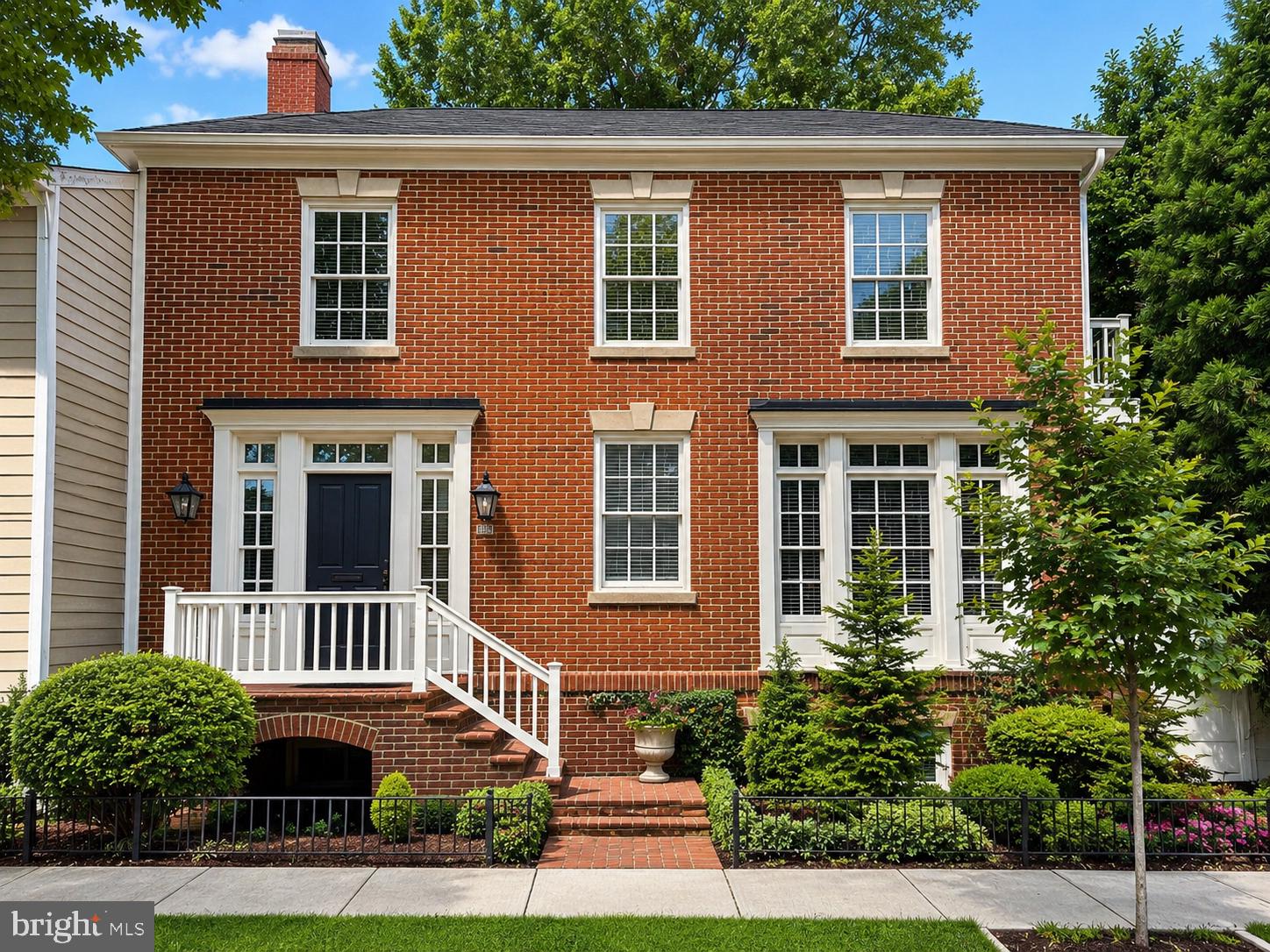 Perfectly located in the Old & Historic District of central Old Town, this 4-bedroom residence with attached garage offers a rare combination of historic setting, thoughtful design, and everyday convenience near Metro, restaurants, and shopping. Designed by Morris-Day Associates and constructed in 1994, this one-of-a-kind home is being offered for sale for the first time. The low-maintenance brick exterior features masonry on all sides, cast keystones, true divided-light windows, and Bevolo gas light fixtures at the front entrance. The attached side-load garage is finished with polished concrete floors, a Tesla charging station, custom built-in cabinetry, and pull-down access to a large storage area above.
Front, side, and rear garden areas are served by a zoned irrigation  system. A covered side porch with Ipe decking overlooks a private garden with stone wall seating, an arbor, and water feature.
Inside, the traditional floor plan is enhanced by four exposures, filling the home with natural light throughout the day. The main level features 9-foot ceilings, a rear staircase, hardwood flooring, and solid architectural detailing. A custom-designed and fabricated Indiana limestone fireplace serves as the focal point of the living room, framed by arched bookcases, a box beam ceiling, and columns.
French doors open to a Tanglewood conservatory with English ceiling blinds, heated slate floors, ceiling fan, and dedicated HVAC system. In the kitchen, limestone floors are complemented by natural cherry cabinetry, granite countertops, Sub-Zero refrigeration, and a Wolf gas range.
The upper-level primary suite features a vaulted ceiling with fan, private balcony, walk-in closet with washer/dryer hookup, and en suite bath with steam shower. Two additional bedrooms share a full bath, with a convenient laundry chute to the lower level.
The lower level offers a complete in-law suite with separate entrance, full kitchen, bedroom, full bath, and living room with French doors opening to the rear garden, with access to the garage and alley.  This home has no common wall with neighboring home and no HOA. Enjoy the quiet no bus line or cut through on a tree lined street just 1 block to historic  Robert E Lee's boyhood home and only a few blocks to the Potomac river and parks. Owner licensed real estate agent