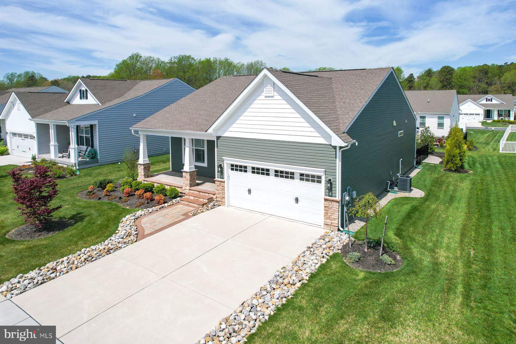 *** BACK ON THE MARKET AT A NEW PRICE***Welcome to refined coastal living in the highly sought-after Villages at Red Mill Pond—perfectly positioned next to the scenic Georgetown-Lewes Bike Trail and just a short drive to the beaches and vibrant shopping of Lewes and Rehoboth Beach. Here, thoughtful upgrades, timeless design, and everyday convenience come together in this beautifully enhanced 3-bedroom, 2-bath home. From the moment you arrive, the charming front elevation, professionally landscaped walkway, and inviting front porch set the tone. Inside, a light-filled, open-concept layout showcases luxury vinyl plank flooring throughout and soaring vaulted ceilings that create an airy, expansive feel. The gourmet kitchen is a true centerpiece, featuring Level 5 cabinetry—the highest grade offered—paired with upgraded granite countertops, crown and shoe molding, and a stylish butler’s pantry with beverage center. A premium Café appliance suite completes the space with elevated form and function. The living area exudes warmth and character, highlighted by custom shiplap accents and a striking stone fireplace with an upgraded blower—perfect for cozy evenings. Plantation shutters add timeless elegance throughout. Step outside to your backyard retreat, complete with a screened porch with shades, full fencing, irrigation, privacy trees, and thoughtfully placed stepping stones. A dedicated gas line for your grill makes outdoor entertaining effortless. With upgraded Norman Rockwell siding, elevated finishes throughout, and an unbeatable location for both recreation and relaxation, this home offers the ideal blend of coastal lifestyle and modern luxury.
