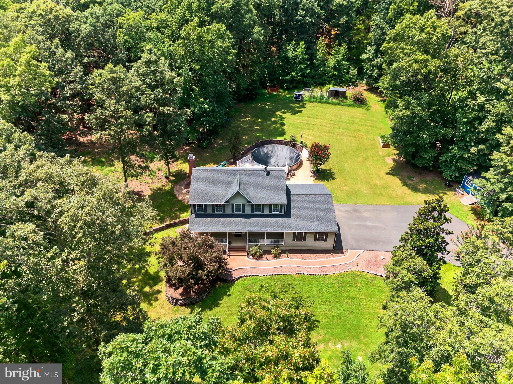 Welcome to your private 6.4-acre farmette retreat with NO HOA! This beautifully updated colonial offers the perfect blend of country charm and modern living. From the end of the cul-de-sac, a newly paved driveway winds its way to the secluded home, and a stamped concrete walkway welcomes you to the inviting front porch. Inside, the main level features hardwood flooring, a formal dining room on the right, and an open living room on the left, with a wood burning fireplace & brick mantel.  Enjoy the updated kitchen with granite counters, black stainless appliances, Bosch dishwasher, and island. There is a pantry closet in the kitchen, and an oversized pantry room in the adjacent hallway.  The main level bedroom has a closet, tile flooring, walk-out door, & new exterior deck/steps, and is currently set up as an entry room with a built-in hall tree. Upstairs, the owner’s suite includes a soaking tub, double vanity, and walk-in closet with built-ins.  There are two other bedrooms on this level, along with the hallway bathroom and laundry room which have both been beautifully updated. The finished basement offers a 5th BR (NTC), full bath, home gym, office/storage room, recreation room (with game table lighting), and a storage/safe room. Outside, entertain on the multi-level deck, relax by the pool, or gather around the stone firepit, with a stamped concrete walkway and patio. Bring your animals- the property is ready for chickens, goats, and more!  The exterior also includes a large shed, chicken coop area, animal shed, raised garden bed, target range, and trails around the property.  The septic system just had about 14k in updates including a new 1000 gallon pump tank & controls, new distribution box, and new header lines. Other updates in recent years include newly paved driveway (14k), roof, black gutters, HVAC systems, Nest thermostats & sensors, water heater, basement walk-out door, ceiling fans, light fixtures, video doorbell, pool equipment, generator switch, and whirlpool water softener.  Fawn Hills offers a prime location, minutes from commuter routes, shopping,  schools, historic battlefields, the Hunting Run Reservoir, & Rapidan River access.  Xfinity high speed internet is in place, great for remote work and streaming.  Don’t miss your opportunity to be the next owner of this amazing property!