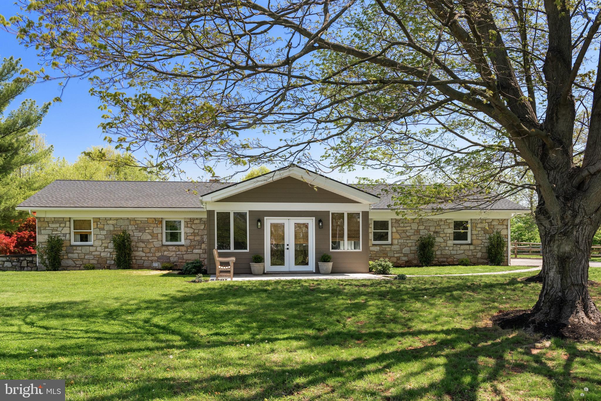 Welcome to 723 Saylors Mill Rd, a truly exceptional property set on 11.3 private acres in Spring City. This fully renovated 5-bedroom, 4.5-bath ranch home offers a rare combination of modern living, expansive outdoor space, and incredible versatility with two large barns—ideal for a variety of residential or business uses. With its generous acreage, the property may also offer potential for Act 319 enrollment, providing an added opportunity for tax benefits. From the moment you arrive, you’re greeted by picturesque surroundings and a sense of privacy that makes this property truly special. Inside, beautiful hardwood flooring flows throughout, complemented by stunning wood-paneled ceilings that bring warmth and character to the main living areas. The welcoming sunroom with heated flooring at the front of the home is filled with natural light and seamlessly leads into the open-concept family room and dining area, complete with a gas fireplace. The thoughtfully designed kitchen is the heart of the home, featuring a large center island with seating, stainless steel appliances, striking countertops and backsplash, and abundant cabinetry. A set of double glass doors just off the kitchen leads directly to the back patio, creating the perfect setup for effortless indoor-outdoor living and entertaining. Just beyond, a comfortable den provides additional living space, highlighted by its own set of elegant double glass doors. A conveniently located laundry room and powder room complete this area. The bedroom wing offers privacy and comfort, highlighted by a spacious primary suite with built-in cabinetry, direct access to the back patio, and a beautifully appointed en-suite bath featuring a double vanity, soaking tub, walk-in shower, and private water closet. An additional princess suite includes its own walk-in shower, while the remaining bedrooms are generously sized and share a well-appointed full hall bath. The finished lower level adds even more flexibility with a full in-law suite, complete with a living area, kitchen, bedroom, full bath, laundry and private exterior entrance—ideal for extended family, guests, or multi-generational living. Step outside to your own private retreat, where a fenced-in patio and hot tub create the perfect space to relax and unwind. The property’s two large barns elevate this offering even further—one of which has been converted into a functional office space featuring a private office, bathroom, kitchenette, workspace, and warehouse area, along with a covered, fenced-in outdoor patio—perfect for a home business, studio, or creative workspace. With its unique blend of updated living space, expansive acreage, and unmatched versatility, this one-of-a-kind property offers endless possibilities in a peaceful, private setting. Schedule your private showing today!