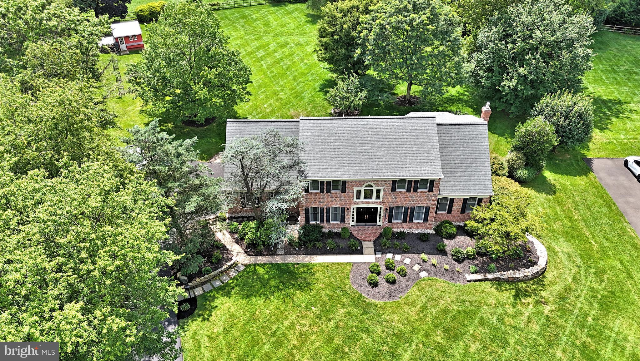 Discover unparalleled elegance in this exquisitely updated brick-front colonial, nestled within the highly sought-after Brookwood Estates. Situated on a magnificent 1.37-acre park-like lot, this home effortlessly combines sophisticated design with every modern amenity imaginable.

Upon entering, a grand double doorway reveals an expansive, sun-drenched foyer showcasing a striking curved staircase. To your left, a formal living room invites relaxation, while the elegant dining room to your right sets the stage for memorable gatherings. The entire main level exudes warmth with timeless hardwood floors, creating a seamless flow throughout the inviting floorplan.

The state-of-the-art kitchen is truly the heart of this home, equipped with top-tier appliances including a Wolf gas-powered cooktop, Sub-Zero refrigerator, and a large center island. Thoughtful additions like a beverage fridge and coffee bar enhance convenience, making it ideal for entertaining. This eat-in kitchen flows effortlessly into the family room, which boasts custom built-ins, a charming brick gas fireplace, and direct access to a dedicated home office. The main floor also includes a laundry room with commercial-grade appliances and direct backyard access, plus a spacious three-car garage with new epoxy flooring.

Upstairs, a welcoming landing leads to the private owner's suite, a spacious retreat featuring a cozy sitting room and a newly remodeled spa-like bathroom with heated floors. Indulge in the beautiful shower stall, freestanding soaking tub, and double vanity, complemented by two ample closets. Across the hall, secondary bedrooms offer comfort and style, including an extra-large fourth bedroom distinguished by two walk-in closets. An updated hall bath serves these rooms. The finished basement, complete with durable wood tile flooring, provides additional versatile living space, a bonus room, and a full bath.

Embrace outdoor living at its finest! The screened-in porch, featuring a granite bar, skylights, and ceiling fans, is perfect for year-round enjoyment. Step out onto the custom-built paver patio with a grill light and be captivated by incredible sunsets overlooking your personal apple orchard and charming chicken coop. An invisible fence offers peace of mind for pet owners. This turnkey residence provides immediate access to Northampton Township Park's extensive amenities, including playgrounds, sports fields, and bike paths. This unique home harmoniously blends classic style with modern comforts, offering a peaceful and private sanctuary.