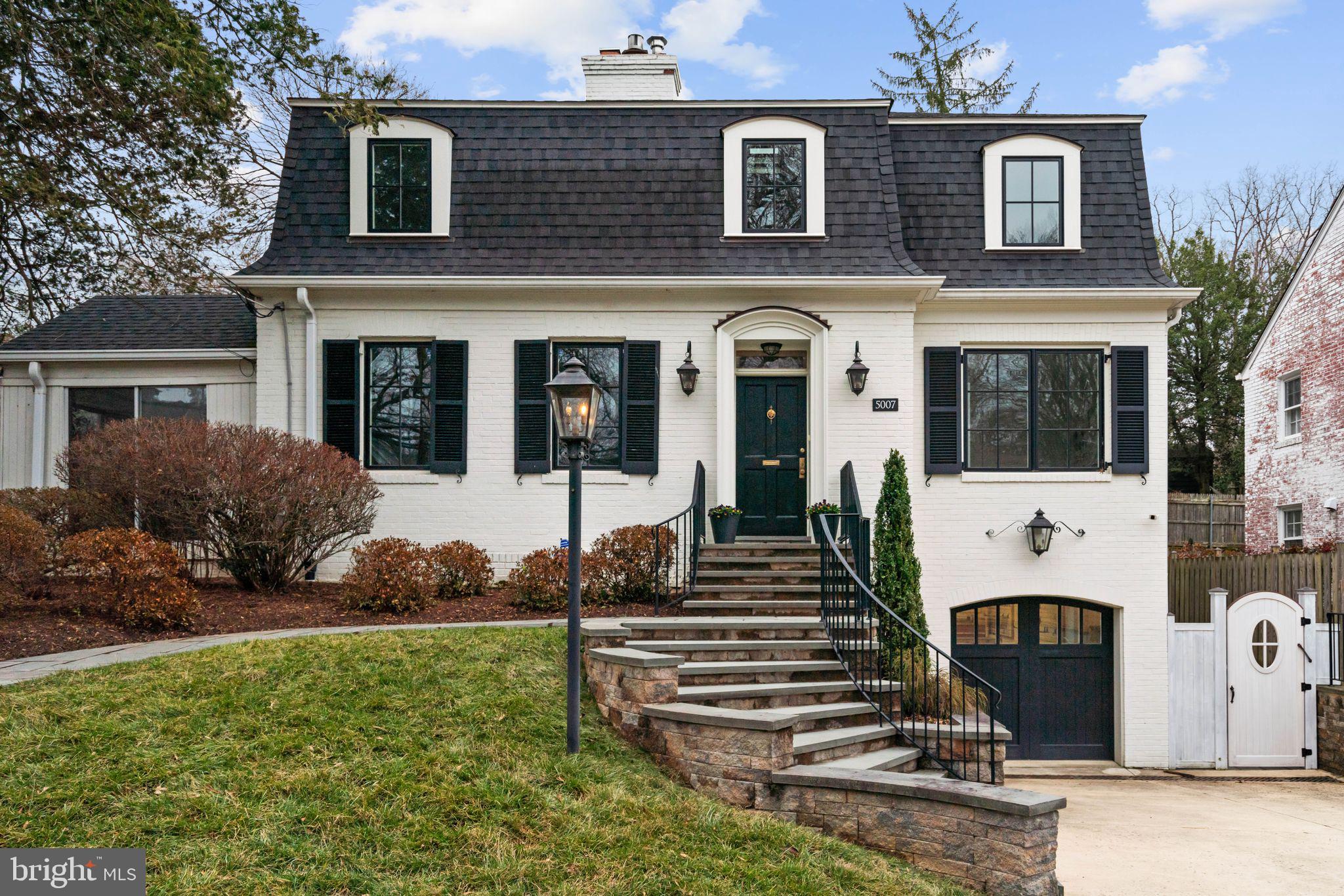 Enchanting, light-filled, beautifully sited. Welcome to this expanded five bedroom home in “The Westbrook Neighborhood.” Thoughtfully updated and renovated by Anthony Wilder, 5007 Baltimore Avenue blends classic charm with a calm, Scandinavian-inspired sensibility that emphasizes light, openness, and livable elegance. The home enjoys tremendous curb appeal, hinting at the warmth and character within -- arched doorways, interesting woodwork, gleaming hardwood floors, and large windows that draw sunlight into the home from both the front and the back. The fantastic floor plan allows for multiple entertaining options, including two back patios overlooking a manicured, fenced-in backyard.
Guests are welcomed by an expansive paved driveway and a curved stairway surrounded by a lush front yard, mature shrubbery, and stone paths. Inside, a traditional center-hall foyer leads to the formal living room, anchored by a fireplace, as well as a versatile first-floor bedroom option with murphy bed. The elegant dining room boasts chair rail molding and French doors opening to the back patio and connects seamlessly to the stunning, light-filled kitchen. Here, design and function come together with stainless steel appliances including a gas range, built-in microwave, and wine refrigerator, along with a gorgeous farmhouse sink, pantry, and built-ins. A mudroom off the kitchen, accessed from a side door, allows for excellent daily flow into the home. A cheery sunroom, also with patio access, and a powder room complete the main level.
Upstairs are four generously sized bedrooms, including the owner’s bedroom with dual closets and an en suite full bath. A convenient second-floor laundry room, a full hall bath with two sinks, and linen closets add everyday practicality. What is even more fun? One bedroom includes a cozy sleeping loft above the bedroom which is bound to be a hit. 
The lower level features an oversized recreation room with recessed lighting, a wet bar, and a bonus room, as well as a door to the backyard and access to the attached one-car garage.
The yard is a standout. Fully fenced, it provides multiple entertainment options for both two- and four-legged friends. Large enough to accommodate another addition in the future, or just double-down on the flowers and garden. It’s a true retreat.
5007 Baltimore Avenue benefits from neighborhood parks and trails and is convenient to Friendship Heights, Spring Valley, Westbard Square, downtown Bethesda, the Capital Crescent Trail, and major transportation routes.
Named one of Bethesda Magazine’s “Great Neighborhoods,” the Westbrook neighborhood is a well-established community that continues to delight residents decade after decade with its Fourth of July and Halloween parades, block parties, and other neighborhood traditions. 5007 Baltimore Avenue is a short stroll to neighborhood favorites including Millie’s, the hometown butcher Wagshal’s, and sidewalk dining at Pizzeria Paradiso, along with Compass Coffee, Crate & Barrel, and the Spring Valley Shopping Center. Just about a mile away are the Friendship Heights Metro and its many conveniences, including dining, shopping, Amazon Grocery, medical offices, Whole Foods, and more.
Westbrook Elementary, Westland Middle, and B-CC High School serve the neighborhood. The home is also inbounds for the Little Falls Swimming Club.  Welcome home to one of the most delightfully maintained and thoughtfully loved homes in the neighborhood.