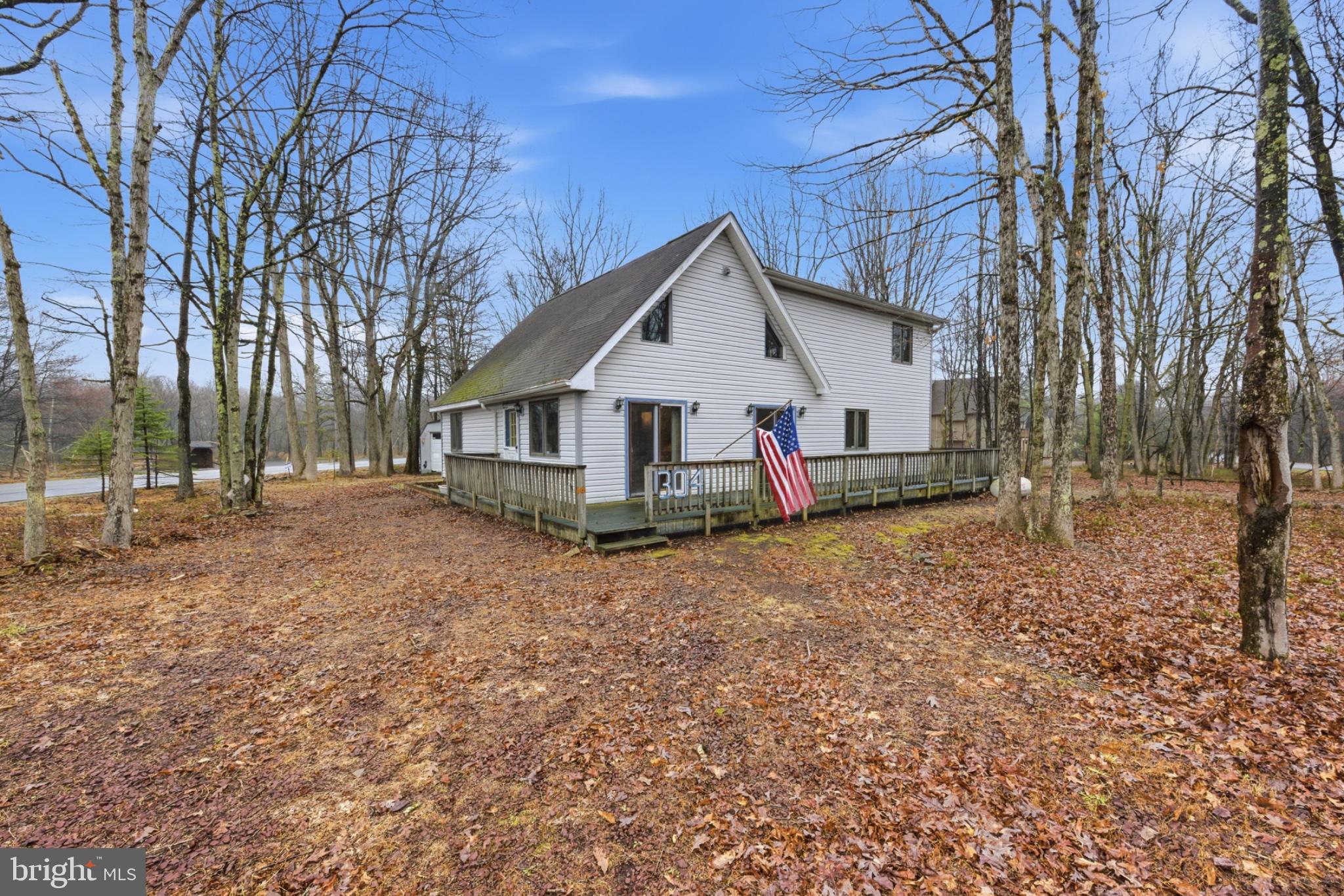This is not a drive-by! Motivated sellers! 100% financing available for qualified owner-occupied buyers with USDA Financing, including some renovations.  Located in a desirable Pocono setting, this spacious chalet presents a compelling opportunity for those looking to invest in a short-term rental property with strong year-round appeal. Its expanded A-frame design, soaring ceilings, and sun-filled interior create the warm, inviting atmosphere today’s guests seek when booking a getaway. The community features several amenities: a 195-acre lake with a beach for boating, swimming, and fishing; tennis and pickleball courts; a bocce court and horseshoe pits; basketball courts; and a marina area for launching owner-registered boats. A convenient trash and recycling drop-off area is open 365 days a year. 
The home’s flexible layout is well-suited for hosting groups, offering multiple living and sleeping areas that can comfortably accommodate a variety of guest configurations. The open-concept living room with cathedral ceilings provides a central gathering space, while the large eat-in kitchen allows for easy entertaining—both key features that enhance guest experience and booking potential. As a rental, the property's current characteristics allow up to a 10-person nightly occupancy. As a non-rental, the property may be occupied by more than 10 people overnight.
Outdoor living is equally appealing, with a covered patio that lets guests enjoy the space in any weather and a wraparound deck that expands the usable living area. The covered patio is a perfect location for a hot tub, offering shelter from the weather and a touch of privacy. Thoughtful features like these help create memorable stays, encouraging repeat bookings and positive reviews. 
The interior flow is functional and practical, with first-floor bedrooms and a full bath providing convenience, while the upper level expands the home’s versatility. The private upper-level main bedroom with rear balcony offers a quiet retreat, and the expansive loft—overlooking the main living area—can serve as additional sleeping quarters, entertainment space, or a flexible bonus area to maximize occupancy.
With solid bones and room for cosmetic updates, this property offers the opportunity to enhance value and tailor the design to today’s rental market, potentially increasing rental appeal to offset your costs.  A modest reconfiguration of the immense upper level could allow up to two additional bedrooms, but would require increasing the septic capacity if the home is rented.
Whether used exclusively as an investment or enjoyed personally while generating income when not in use, this property offers a smart combination of comfort, flexibility, and earning potential in a popular vacation destination. The location near the township-maintained road ensures quick attention to plowing for travel in the Winter season.